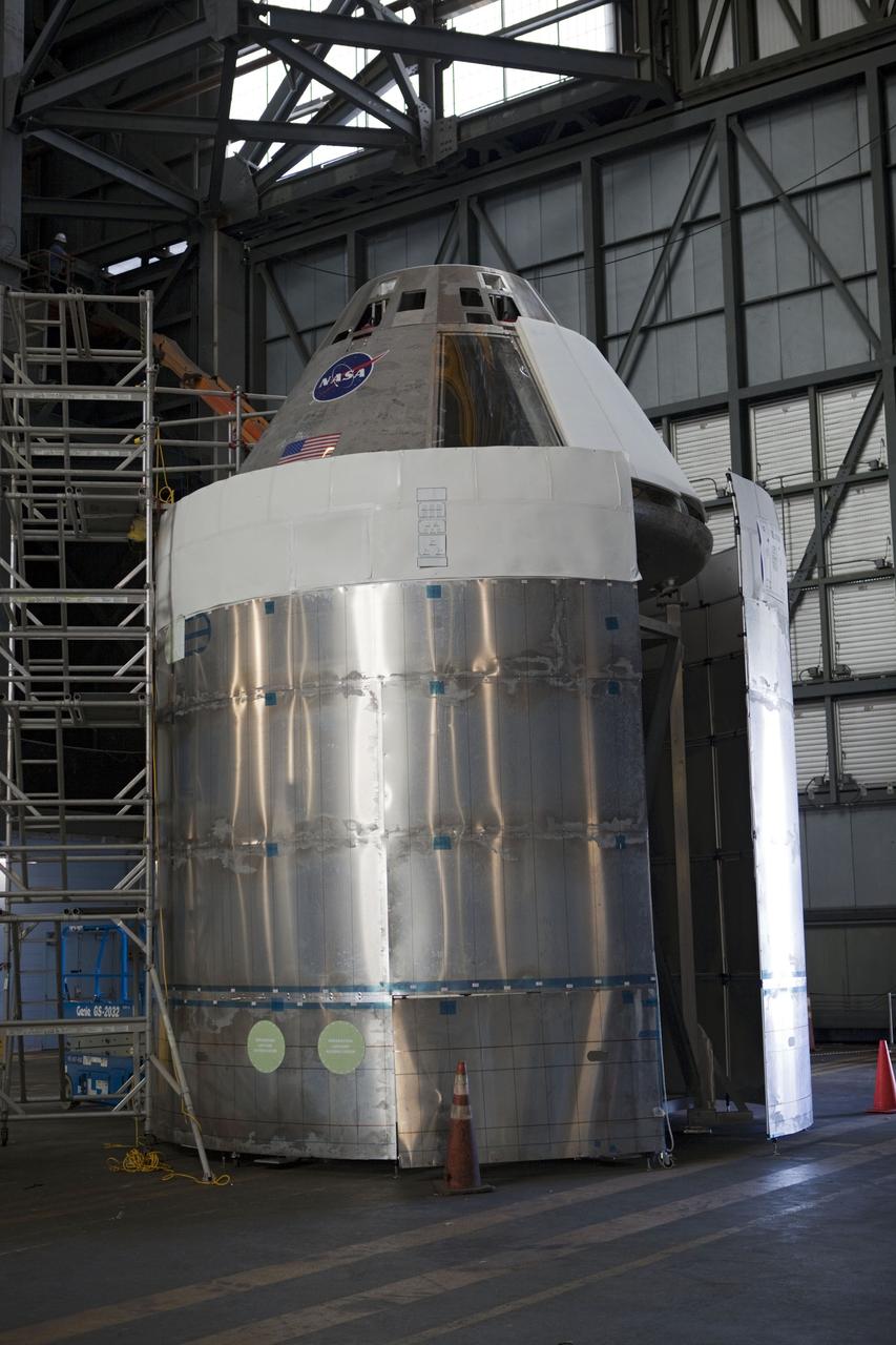 CAPE CANAVERAL, Fla. – The Orion mockup spacecraft sits atop its service module simulator in the transfer aisle of the Vehicle Assembly Building, or VAB, at NASA's Kennedy Space Center in Florida. Orion is the exploration spacecraft designed to carry crews to space beyond low Earth orbit. It will provide emergency abort capability, sustain the crew during the space travel and provide safe re-entry from deep space return velocities. The first uncrewed test flight of the Orion is scheduled to launch in 2014 atop a Delta IV rocket and in 2017 on a Space Launch System rocket. The Orion mockup is exact in details on the outside, but mostly empty on the inside except for four mockup astronaut seats and hatch. The work in the VAB is crucial to making sure the designs are accurate. For more information, visit http://www.nasa.gov/orion Photo credit: NASA/ Dmitri Gerondidakis