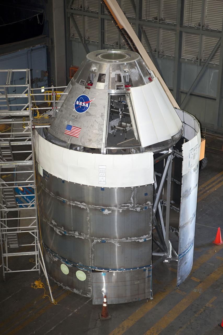 CAPE CANAVERAL, Fla. – The Orion mockup spacecraft sits atop its service module simulator in the transfer aisle of the Vehicle Assembly Building, or VAB, at NASA's Kennedy Space Center in Florida. Orion is the exploration spacecraft designed to carry crews to space beyond low Earth orbit. It will provide emergency abort capability, sustain the crew during the space travel and provide safe re-entry from deep space return velocities. The first uncrewed test flight of the Orion is scheduled to launch in 2014 atop a Delta IV rocket and in 2017 on a Space Launch System rocket. The Orion mockup is exact in details on the outside, but mostly empty on the inside except for four mockup astronaut seats and hatch. The work in the VAB is crucial to making sure the designs are accurate. For more information, visit http://www.nasa.gov/orion Photo credit: NASA/ Dmitri Gerondidakis