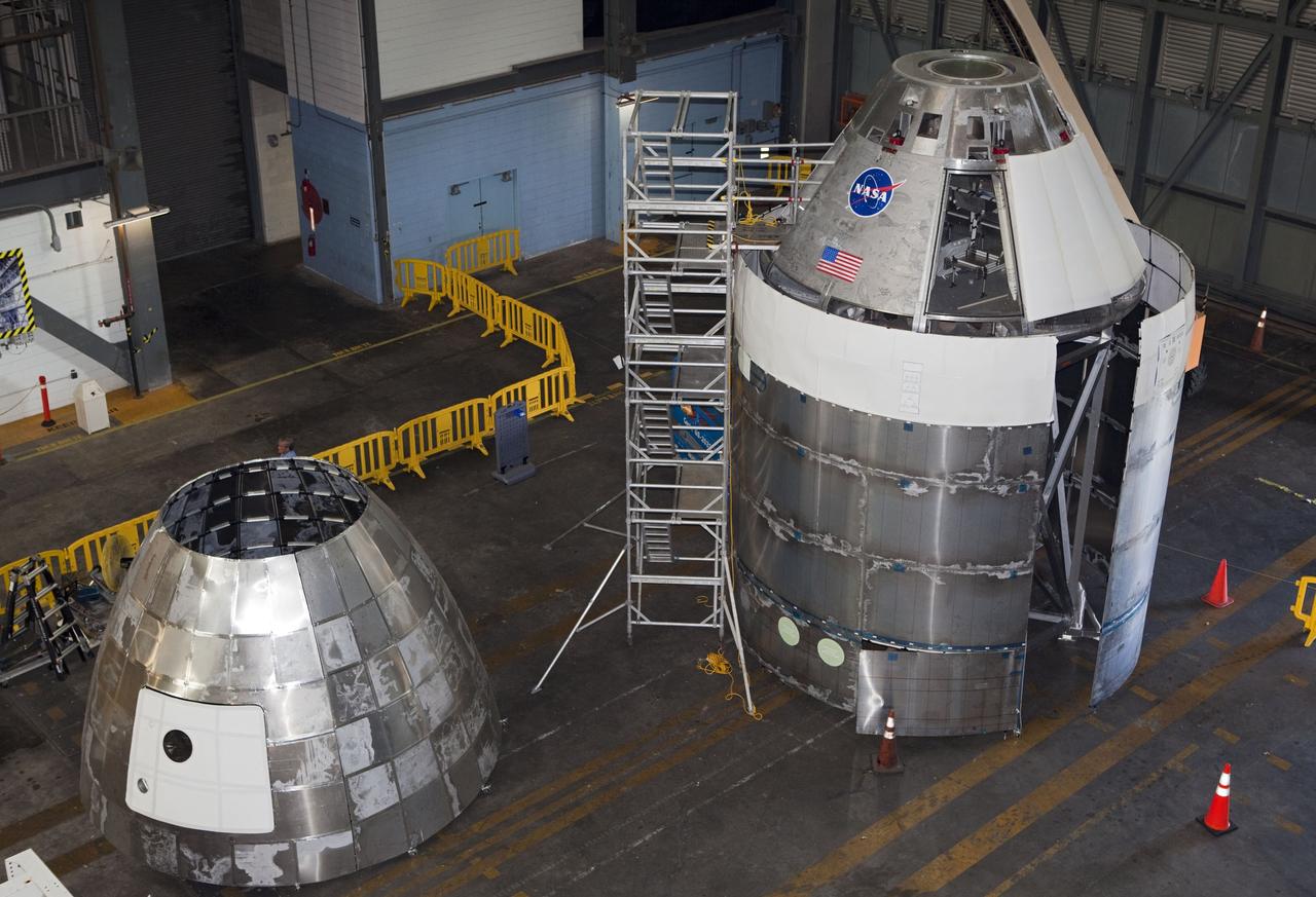 CAPE CANAVERAL, Fla. – The Orion mockup spacecraft sits atop its service module simulator in the transfer aisle of the Vehicle Assembly Building, or VAB, at NASA's Kennedy Space Center in Florida. To the left is the aerodynamic shell that will cover the capsule during launch. Orion is the exploration spacecraft designed to carry crews to space beyond low Earth orbit. It will provide emergency abort capability, sustain the crew during the space travel and provide safe re-entry from deep space return velocities. The first uncrewed test flight of the Orion is scheduled to launch in 2014 atop a Delta IV rocket and in 2017 on a Space Launch System rocket. The Orion mockup is exact in details on the outside, but mostly empty on the inside except for four mockup astronaut seats and hatch. The work in the VAB is crucial to making sure the designs are accurate. For more information, visit http://www.nasa.gov/orion Photo credit: NASA/ Dmitri Gerondidakis