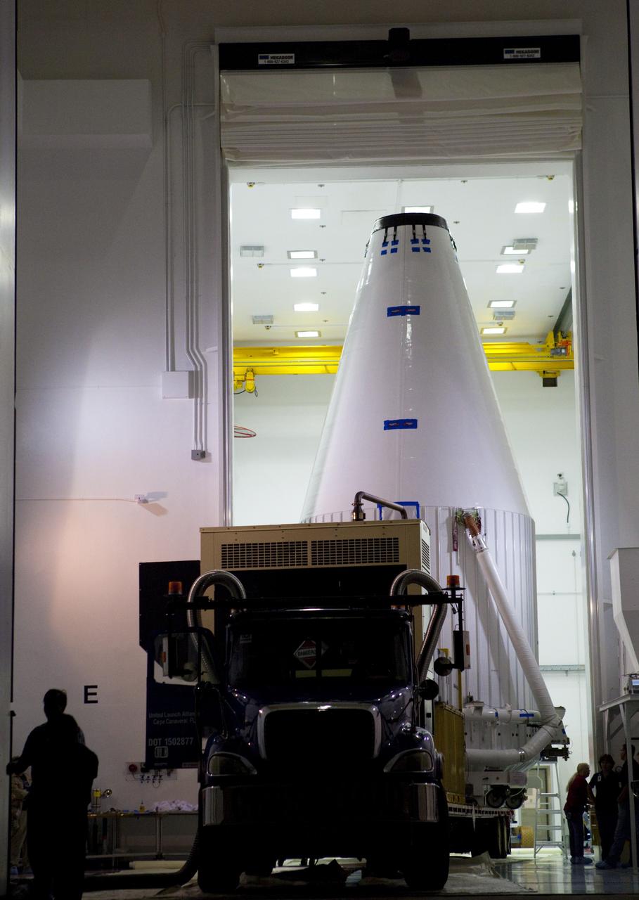 CAPE CANAVERAL, Fla. – The Radiation Belt Storm Probes, or RBSP, spacecraft are moved inside their payload fairing on the payload transporter from the Astrotech payload processing facility in Titusville, Fla. to Space Launch Complex-41 at Cape Canaveral Air Force Station. The fairing, which holds the twin RBSP spacecraft, will be lifted to the top of a United Launch Alliance Atlas V rocket for launch later in August. The two spacecraft are designed to study the Van Allen radiation belts in unprecedented detail. Photo credit: NASA/Dmitri Gerondidakis