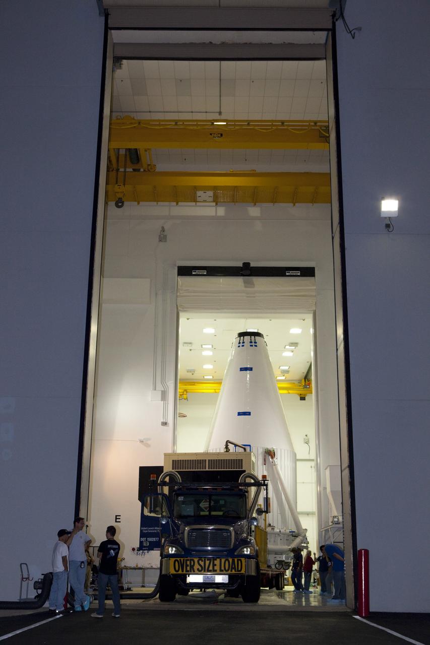 CAPE CANAVERAL, Fla. – The Radiation Belt Storm Probes, or RBSP, spacecraft are moved inside their payload fairing on the payload transporter from the Astrotech payload processing facility in Titusville, Fla. to Space Launch Complex-41 at Cape Canaveral Air Force Station. The fairing, which holds the twin RBSP spacecraft, will be lifted to the top of a United Launch Alliance Atlas V rocket for launch later in August. The two spacecraft are designed to study the Van Allen radiation belts in unprecedented detail. Photo credit: NASA/Dmitri Gerondidakis