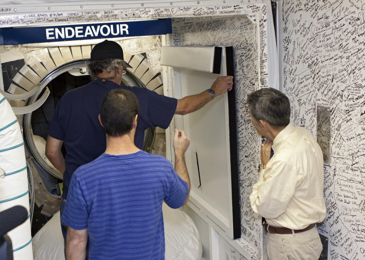 CAPE CANAVERAL, Fla. – In Orbiter Processing Facility Bay 2 at NASA’s Kennedy Space Center in Florida, Kennedy Space Center Director Bob Cabana, far right, watches as United Space Alliance technicians Gary Hamilton, foreground, and Joe Walsh begin preparations to close the space shuttle Endeavour's hatch. The orbiter is undergoing final preparations for its cross-country ferry flight to California. The work is part of Transition and Retirement of the remaining space shuttles, Endeavour and Atlantis. Endeavour is being prepared for public display at the California Science Center in Los Angeles. Its ferry flight to California is targeted for mid-September. Endeavour was the last space shuttle added to NASA’s orbiter fleet. Over the course of its 19-year career, Endeavour spent 299 days in space during 25 missions. For more information, visit http://www.nasa.gov/transition Photo credit: NASA/ Jim Grossmann
