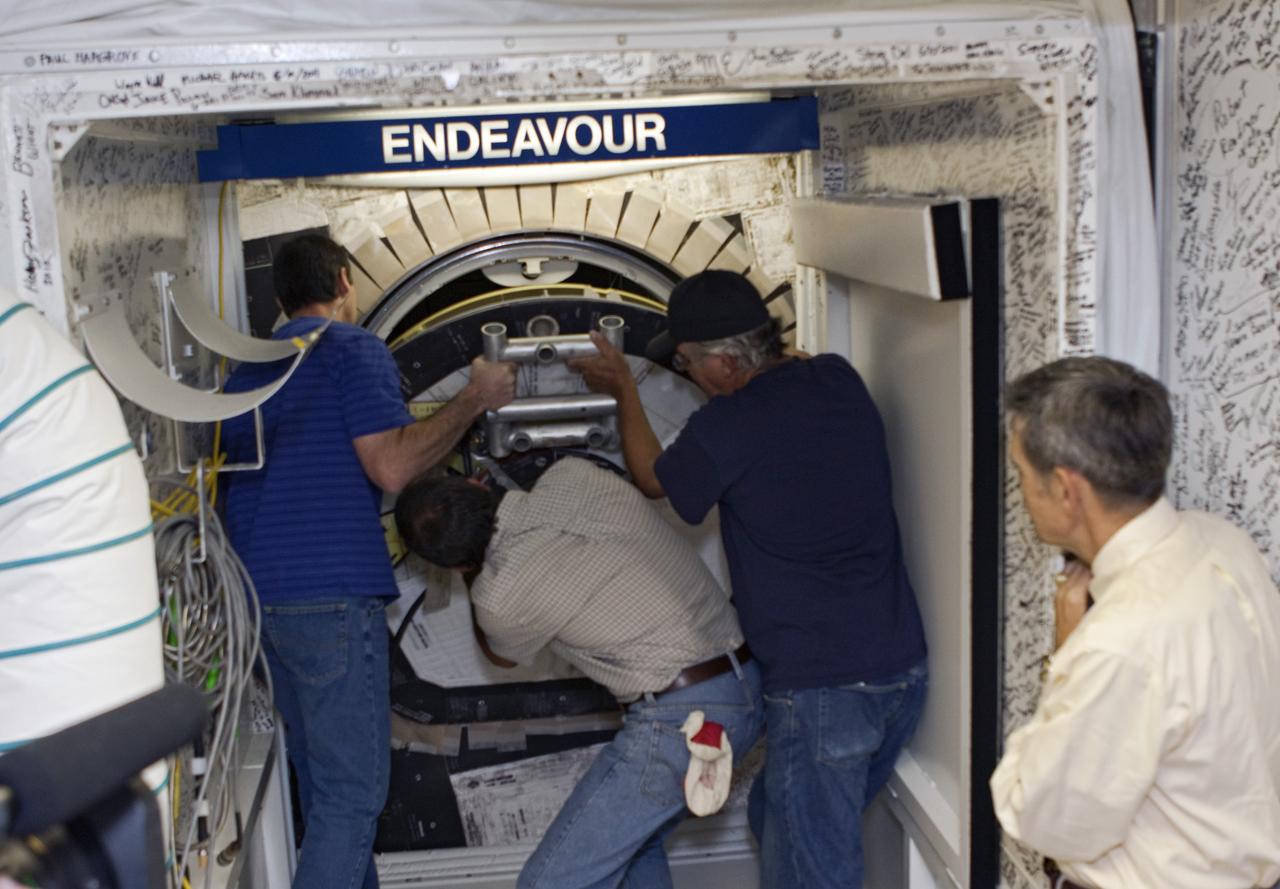 CAPE CANAVERAL, Fla. – In Orbiter Processing Facility Bay 2 at NASA’s Kennedy Space Center in Florida, Kennedy Space Center Director Bob Cabana, far right, watches as, left to right, United Space Alliance technicians Gary Hamilton, Bobby Wright and Joe Walsh begin closing the space shuttle Endeavour's hatch. The orbiter is undergoing final preparations for its cross-country ferry flight to California. The work is part of Transition and Retirement of the remaining space shuttles, Endeavour and Atlantis. Endeavour is being prepared for public display at the California Science Center in Los Angeles. Its ferry flight to California is targeted for mid-September. Endeavour was the last space shuttle added to NASA’s orbiter fleet. Over the course of its 19-year career, Endeavour spent 299 days in space during 25 missions. For more information, visit http://www.nasa.gov/transition Photo credit: NASA/ Jim Grossmann