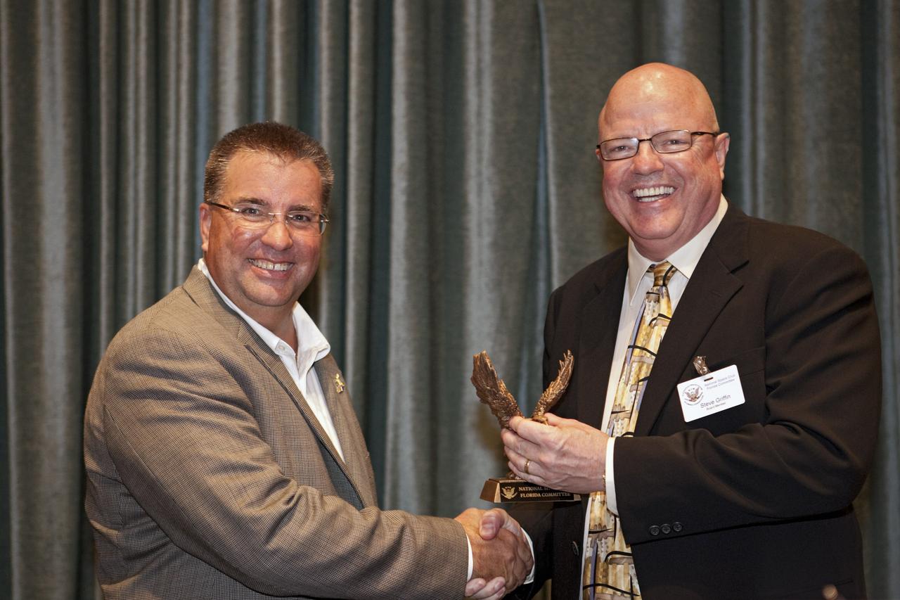CAPE CANAVERAL, Fla. -- National Space Club Florida Committee Chair Steve Griffin presents NASA Commercial Crew Program Manager Ed Mango with an eagle statue during the club's August luncheon at the Radisson Resort at the Port in Cape Canaveral, Fla. Mango was the event's guest speaker, discussing the innovative steps the agency is taking with industry partners to develop the next U.S. space transportation capability to and from low Earth orbit, which will eventually be available for use by the U.S. government and other commercial customers. To learn more about the Commercial Crew Program, visit www.nasa.gov/commercialcrew. Photo credit: Kim Shiflett