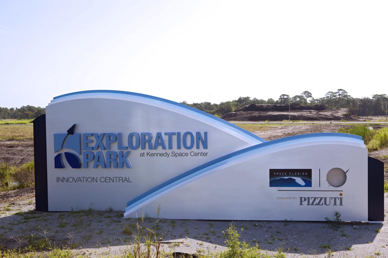 CAPE CANAVERAL, Fla. -- A new sign on Space Commerce Way marks the entrance to Exploration Park near NASA’s Kennedy Space Center in Florida.  Land in the background has been cleared for the first phase of construction.    Exploration Park encompasses 60 acres just outside Kennedy’s security gates. The park is designed to be a strategically located complex, adjacent to the Space Life Sciences Laboratory, for servicing diverse tenants and uses that will engage in activities to support the space-related activities of NASA, other government agencies and the U.S. commercial space industry. Its nine sustainable, state-of-the art buildings will include educational, office, research and laboratory, and high bay facilities and provide 350,000-square-feet of work space. Photo credit: NASA/Dimitri Gerondidakis