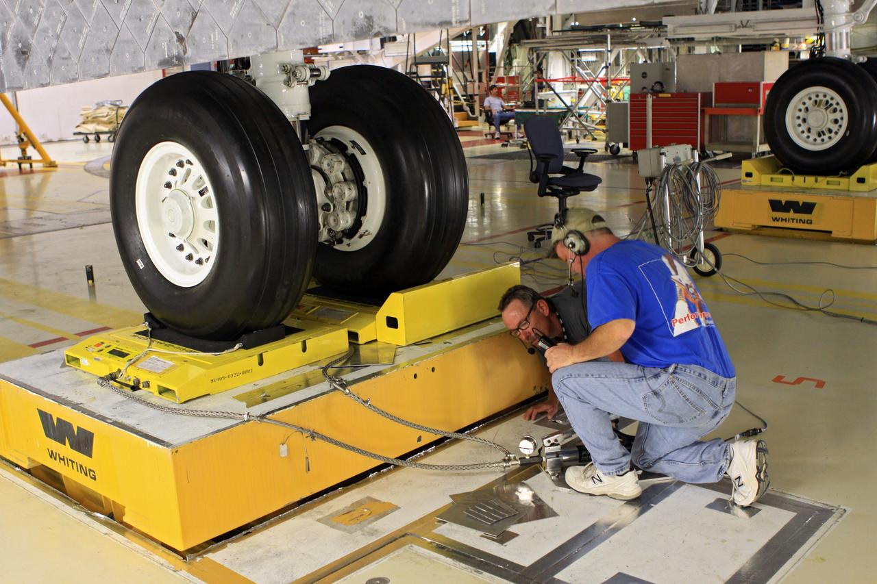 CAPE CANAVERAL, Fla. – In Orbiter Processing Facility Bay 2 at NASA’s Kennedy Space Center in Florida, United Space Alliance aerospace Quality Assurance inspector Dave Bliss, left, and Spherion aerospace technician Scott Palmer complete weight and center of gravity checks on the space shuttle Endeavour. The work is part of Transition and Retirement of the remaining space shuttles, Endeavour and Atlantis. Endeavour is being prepared for public display at the California Science Center in Los Angeles. Its ferry flight to California is targeted for mid-September. Endeavour was the last space shuttle added to NASA’s orbiter fleet. Over the course of its 19-year career, Endeavour spent 299 days in space during 25 missions. For more information, visit http://www.nasa.gov/transition Photo credit: NASA/ Jim Grossmann