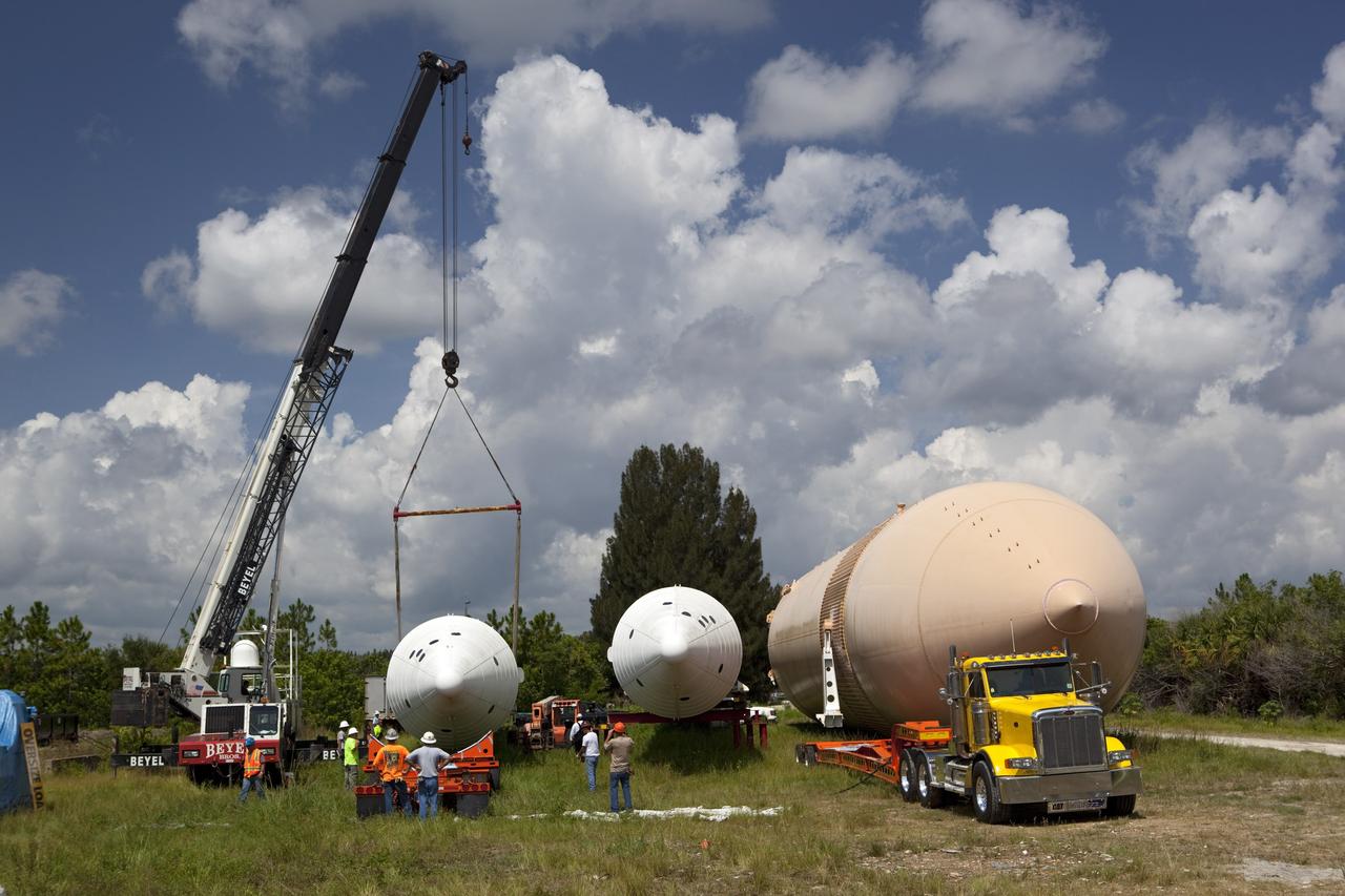 CAPE CANAVERAL, Fla. – At NASA’s Kennedy Space Center in Florida, a crane is used to load a twin set of space shuttle solid rocket boosters and an external fuel tank on trucks for transport to separate museums.      The solid rocket boosters, or SRBs, will be displayed at the California Science Center in Los Angeles. The external tank soon will be transported for display at the Wings of Dreams Aviation Museum at Keystone Heights Airport between Gainesville and Jacksonville, Fla. The 149-foot SRBs together provided six million pounds of thrust. The external fuel tank contained over 500,000 gallons of liquid hydrogen and liquid oxygen propellant for the shuttle orbiters' three main engines. The work is part of Transition and Retirement of the space shuttle. For more information, visit http://www.nasa.gov/transition Photo credit: NASA/ Dimitri Gerondidakis