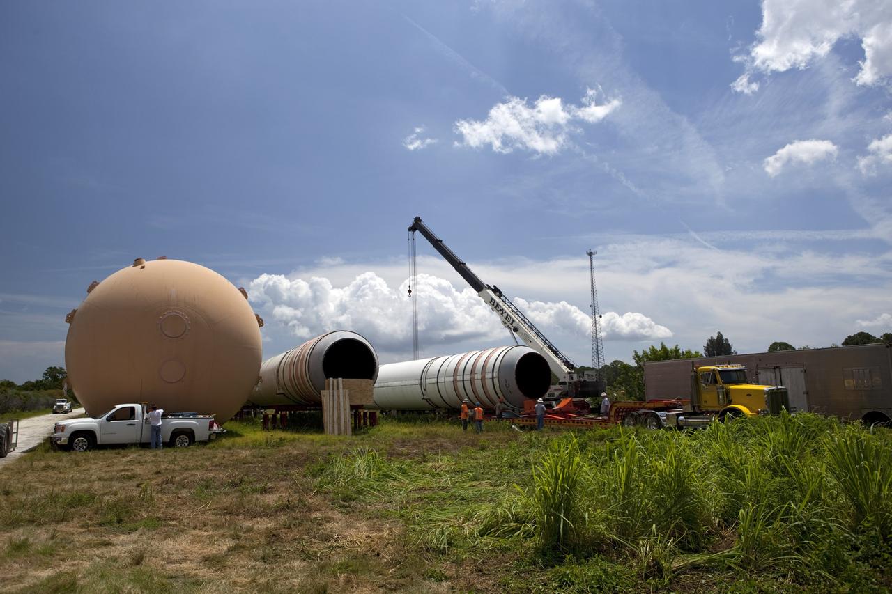 CAPE CANAVERAL, Fla. – At NASA’s Kennedy Space Center in Florida, a crane is used to load a twin set of space shuttle solid rocket boosters and an external fuel tank on trucks for transport to separate museums.      The solid rocket boosters, or SRBs, will be displayed at the California Science Center in Los Angeles. The external tank soon will be transported for display at the Wings of Dreams Aviation Museum at Keystone Heights Airport between Gainesville and Jacksonville, Fla. The 149-foot SRBs together provided six million pounds of thrust. The external fuel tank contained over 500,000 gallons of liquid hydrogen and liquid oxygen propellant for the shuttle orbiters' three main engines. The work is part of Transition and Retirement of the space shuttle. For more information, visit http://www.nasa.gov/transition Photo credit: NASA/ Dimitri Gerondidakis