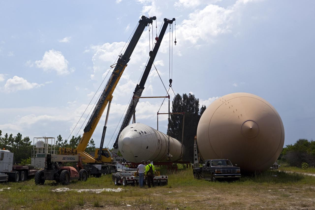 CAPE CANAVERAL, Fla. – At NASA’s Kennedy Space Center in Florida, a crane is used to load a space shuttle solid rocket booster and an external fuel tank on to trucks for transport to separate museums.      The solid rocket boosters, or SRBs, will be displayed at the California Science Center in Los Angeles. The external tank soon will be transported for display at the Wings of Dreams Aviation Museum at Keystone Heights Airport between Gainesville and Jacksonville, Fla. The 149-foot SRBs together provided six million pounds of thrust. The external fuel tank contained over 500,000 gallons of liquid hydrogen and liquid oxygen propellant for the shuttle orbiters' three main engines. The work is part of Transition and Retirement of the space shuttle. For more information, visit http://www.nasa.gov/transition Photo credit: NASA/ Dimitri Gerondidakis