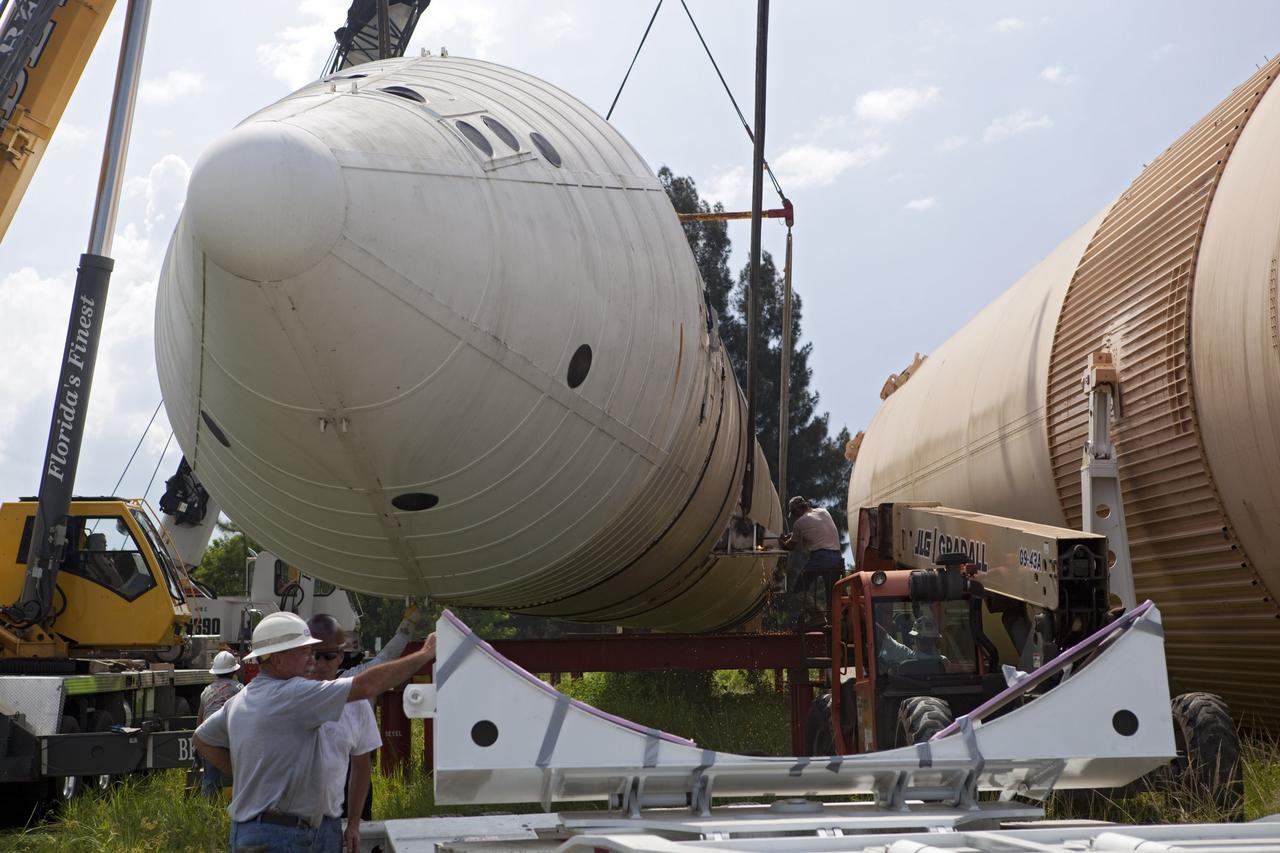 CAPE CANAVERAL, Fla. – At NASA’s Kennedy Space Center in Florida, a crane is used to load a space shuttle solid rocket booster and an external fuel tank on trucks for transport to separate museums.      The solid rocket boosters, or SRBs, will be displayed at the California Science Center in Los Angeles. The external tank soon will be transported for display at the Wings of Dreams Aviation Museum at Keystone Heights Airport between Gainesville and Jacksonville, Fla. The 149-foot SRBs together provided six million pounds of thrust. The external fuel tank contained over 500,000 gallons of liquid hydrogen and liquid oxygen propellant for the shuttle orbiters' three main engines. The work is part of Transition and Retirement of the space shuttle. For more information, visit http://www.nasa.gov/transition Photo credit: NASA/ Dimitri Gerondidakis
