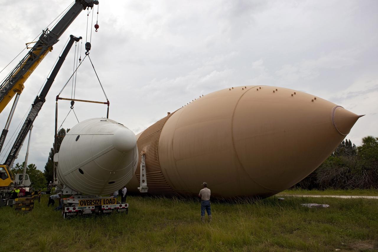 CAPE CANAVERAL, Fla. – At NASA’s Kennedy Space Center in Florida, a crane is used to load a space shuttle solid rocket booster and an external fuel tank on trucks for transport to separate museums.      The solid rocket boosters, or SRBs, will be displayed at the California Science Center in Los Angeles. The external tank soon will be transported for display at the Wings of Dreams Aviation Museum at Keystone Heights Airport between Gainesville and Jacksonville, Fla. The 149-foot SRBs together provided six million pounds of thrust. The external fuel tank contained over 500,000 gallons of liquid hydrogen and liquid oxygen propellant for the shuttle orbiters' three main engines. The work is part of Transition and Retirement of the space shuttle. For more information, visit http://www.nasa.gov/transition Photo credit: NASA/ Dimitri Gerondidakis