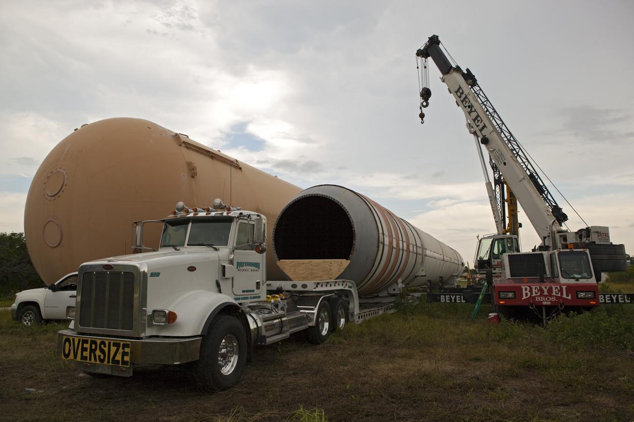 CAPE CANAVERAL, Fla. – At NASA’s Kennedy Space Center in Florida, a crane is used to load a space shuttle solid rocket booster and an external fuel tank on trucks for transport to separate museums.      The solid rocket boosters, or SRBs, will be displayed at the California Science Center in Los Angeles. The external tank soon will be transported for display at the Wings of Dreams Aviation Museum at Keystone Heights Airport between Gainesville and Jacksonville, Fla. The 149-foot SRBs together provided six million pounds of thrust. The external fuel tank contained over 500,000 gallons of liquid hydrogen and liquid oxygen propellant for the shuttle orbiters' three main engines. The work is part of Transition and Retirement of the space shuttle. For more information, visit http://www.nasa.gov/transition Photo credit: NASA/ Dimitri Gerondidakis