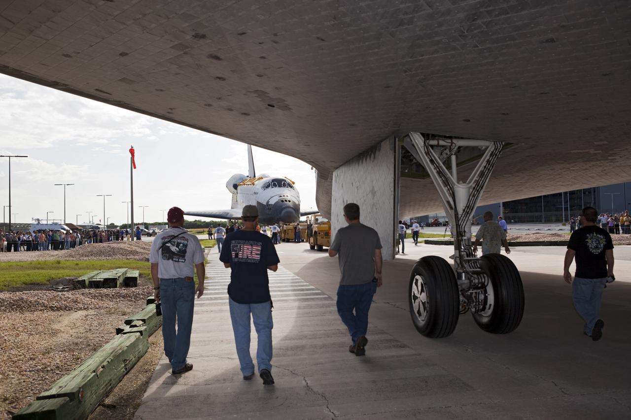 CAPE CANAVERAL, Fla. – As the space shuttle Endeavour approaches shuttle Atlantis, in the background, Kennedy Space Center employees keep a close watch. Endeavour met its sister shuttle for a brief photo opportunity at the Florida spaceport. Endeavour moved from Bay 2 of the Orbiter Processing Facility to switch places with Atlantis which had been in Vehicle Assembly Building VAB. In the VAB, Endeavour will undergo final preparations for its cross-country ferry flight targeted for mid-September. The work is part of Transition and Retirement of the remaining space shuttles, Endeavour and Atlantis. Endeavour is being prepared for public display at the California Science Center in Los Angeles. Endeavour was the last space shuttle added to NASA’s orbiter fleet. Over the course of its 19-year career, Endeavour spent 299 days in space during 25 missions. For more information, visit http://www.nasa.gov/transition Photo credit: NASA/Dimitri Gerondidakis