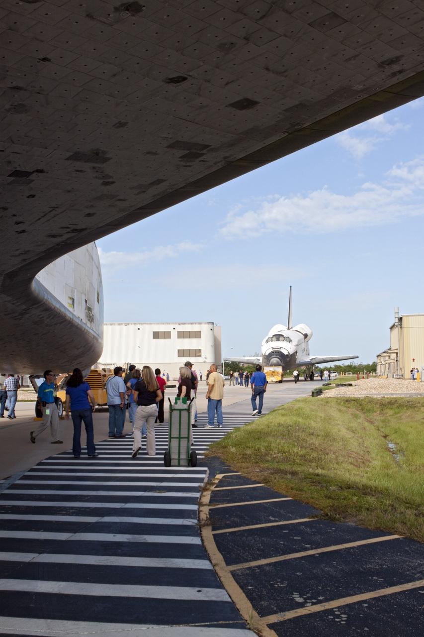 CAPE CANAVERAL, Fla. – Employees at NASA's Kennedy Space Center in Florida keep a watchful eye on the space shuttle Atlantis as it meets sister shuttle Endeavour in the background for a brief photo opportunity. Endeavour moved from Bay 2 of the Orbiter Processing Facility OPF to switch places with Atlantis which had been in Vehicle Assembly Building. In the OPF, Atlantis will undergo final preparations for its transfer to the Kennedy Space Center Visitor Complex targeted for November. The work is part of Transition and Retirement of the remaining space shuttles, Atlantis and Endeavour. Atlantis is being prepared for public display at Kennedy's Visitor Complex. Over the course of its 26-year career, Atlantis spent 293 days in space during 33 missions. For more information, visit http://www.nasa.gov/transition Photo credit: NASA/Kim Shiflett