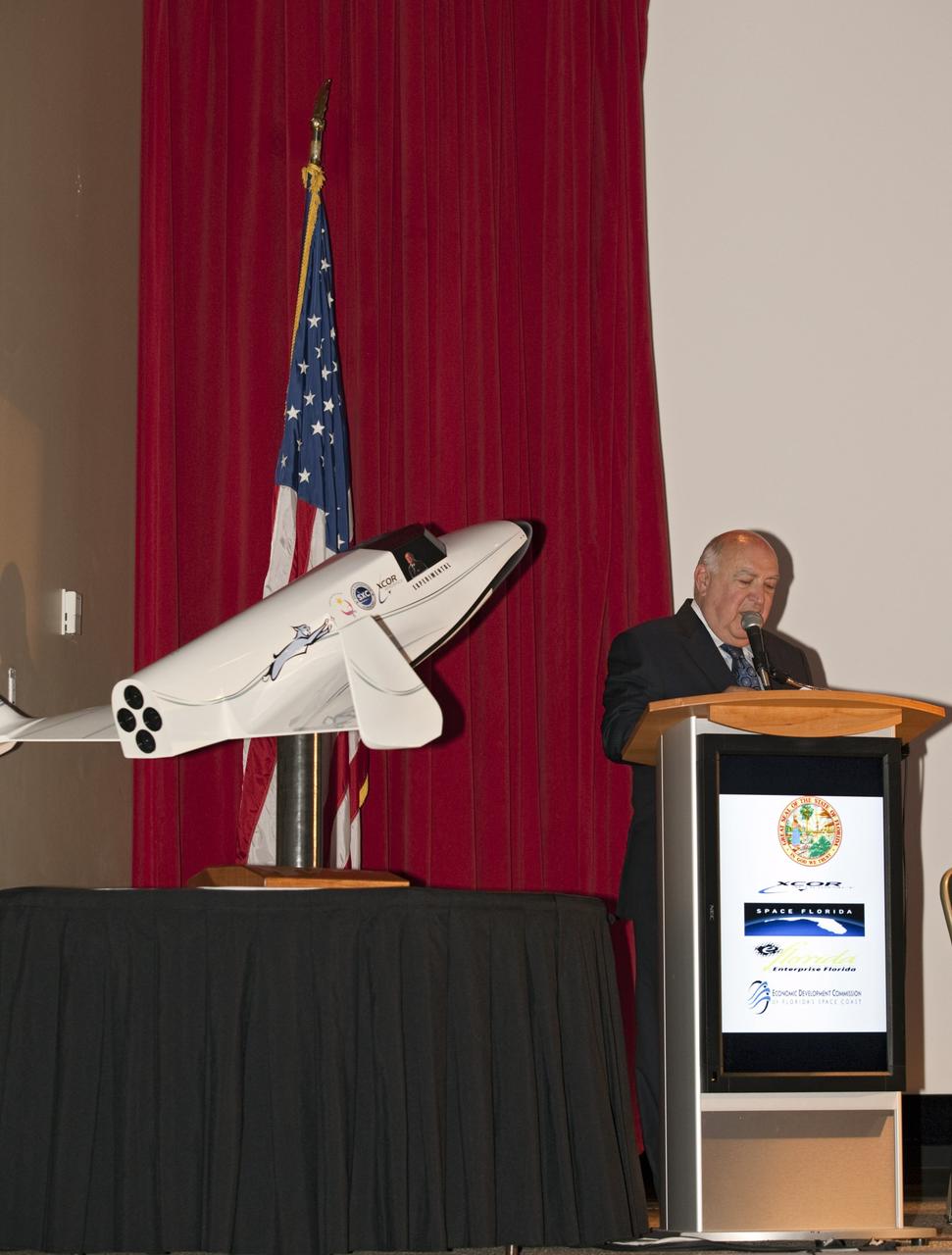 CAPE CANAVERAL, Fla. - At NASA's Kennedy Space Center in Florida, Space Florida President Frank DiBello addresses guests at a presentation during which XCOR Aerospace announced plans to open a manufacturing operation in Brevard County.      The company's suborbital Lynx Mark II spacecraft possibly will take off and land at Kennedy's shuttle landing facility. XCOR Aerospace is a small, privately held California corporation with focus on the research, development, project management and production of reusable launch vehicles, rocket engines and rocket propulsion systems. XCOR will focus on space tourism, experimental flights and launching satellites. Photo credit: NASA/ Frankie Martin