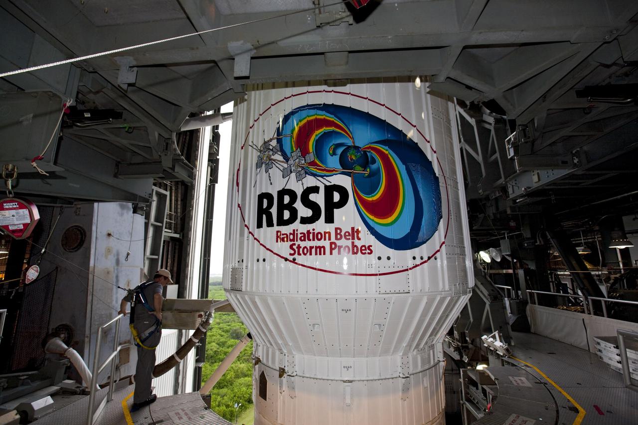 CAPE CANAVERAL, Fla. – At Cape Canaveral Air Force Station in Florida, United Launch Alliance, or ULA, technicians monitor the progress as the Atlas V rocket carrying NASA’s twin Radiation Belt Storm Probes, or RBSP, is moved into the Vertical Integration Facility after rolling back from Space Launch Complex 41. The rocket and spacecraft will be secured and protected from inclement weather due to Tropical Storm Isaac. The RBSP logo on the Atlas V rocket is not a decal. For this mission, the logo was hand painted onto the rocket.      RBSP will explore changes in Earth's space environment caused by the sun -- known as "space weather" -- that can disable satellites, create power-grid failures and disrupt GPS service. The mission also will provide data on the fundamental radiation and particle acceleration processes throughout the universe. The launch is rescheduled for 4:05 a.m. EDT on Aug. 30, pending approval from the range.  For more information on RBSP, visit http://www.nasa.gov/rbsp.  Photo credit: NASA/Ben Smegelsky