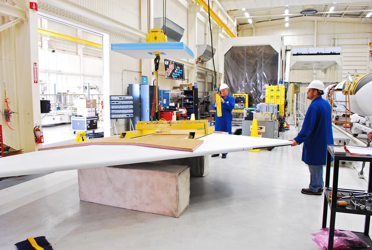 Vandenberg Air Force Base, Calif. – Inside a processing facility at Vandenberg Air Force Base in California, technicians prepare the wing for a fit check with the Orbital Sciences Pegasus XL launch vehicle.    NASA’s Interface Region Imaging Spectrograph, or IRIS, spacecraft will launch aboard the Pegasus XL in late 2012. IRIS will open a new window of discovery by tracing the flow of energy and plasma through the chromospheres and transition region into the sun’s corona using spectrometry and imaging. IRIS fills a crucial gap in our ability to advance studies of the sun-to-Earth connection by tracing the flow of energy and plasma through the foundation of the corona and heliosphere, or region around the sun. Photo credit: NASA/Randy Beaudoin