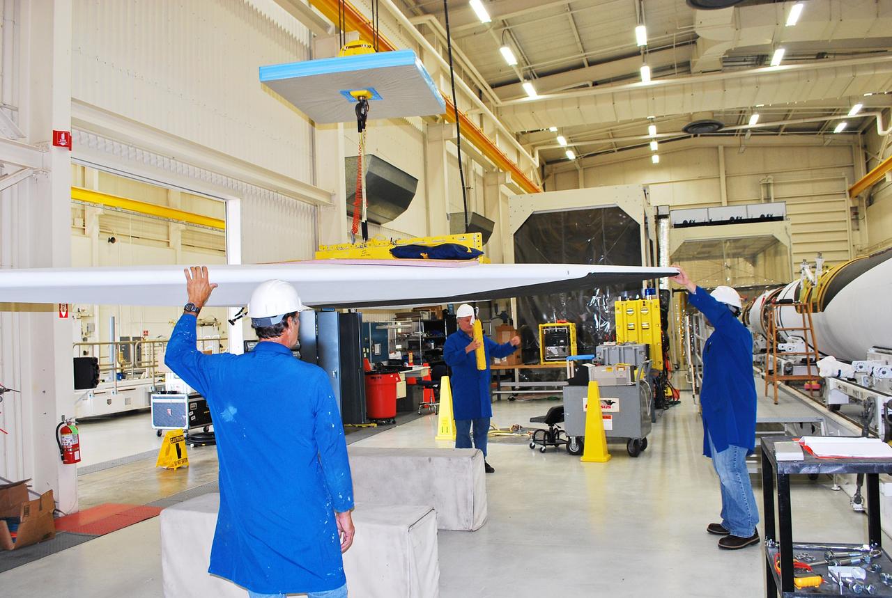 Vandenberg Air Force Base, Calif. – Inside a processing facility at Vandenberg Air Force Base in California, technicians prepare the wing for a fit check with the Orbital Sciences Pegasus XL launch vehicle.    NASA’s Interface Region Imaging Spectrograph, or IRIS, spacecraft will launch aboard the Pegasus XL in late 2012. IRIS will open a new window of discovery by tracing the flow of energy and plasma through the chromospheres and transition region into the sun’s corona using spectrometry and imaging. IRIS fills a crucial gap in our ability to advance studies of the sun-to-Earth connection by tracing the flow of energy and plasma through the foundation of the corona and heliosphere, or region around the sun. Photo credit: NASA/Randy Beaudoin