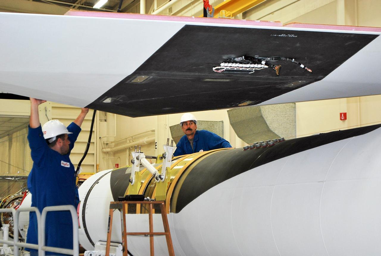 Vandenberg Air Force Base, Calif. – Inside a processing facility at Vandenberg Air Force Base in California, technicians assist as a crane lowers the wing closer for a fit check with the Orbital Sciences Pegasus XL launch vehicle.    NASA’s Interface Region Imaging Spectrograph, or IRIS, spacecraft will launch aboard the Pegasus XL in late 2012. IRIS will open a new window of discovery by tracing the flow of energy and plasma through the chromospheres and transition region into the sun’s corona using spectrometry and imaging. IRIS fills a crucial gap in our ability to advance studies of the sun-to-Earth connection by tracing the flow of energy and plasma through the foundation of the corona and heliosphere, or region around the sun. Photo credit: NASA/Randy Beaudoin