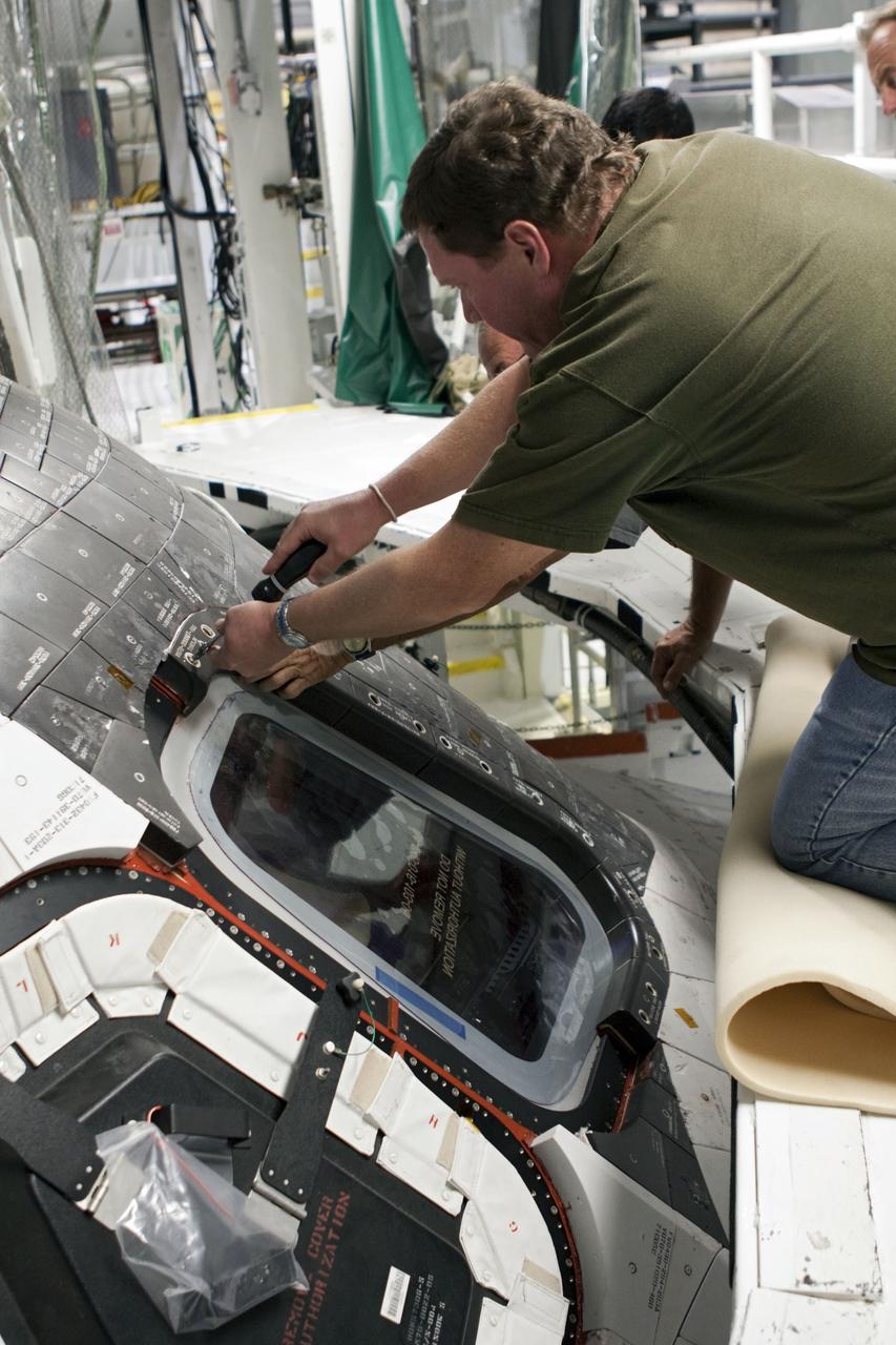 CAPE CANAVERAL, Fla. – At NASA's Kennedy Space Center in Florida, a United Space Alliance technician installs a thermal protection system carrier panel on the space shuttle Atlantis in Bay 2 of the Orbiter Processing Facility. Atlantis is undergoing final preparations for its transfer to the Kennedy Space Center Visitor Complex targeted for November. The work is part of Transition and Retirement of the remaining space shuttles, Atlantis and Endeavour. Atlantis is being prepared for public display at Kennedy's Visitor Complex. Over the course of its 26-year career, Atlantis spent 293 days in space during 33 missions. For more information, visit http://www.nasa.gov/transition Photo credit: NASA/Jim Grossmann