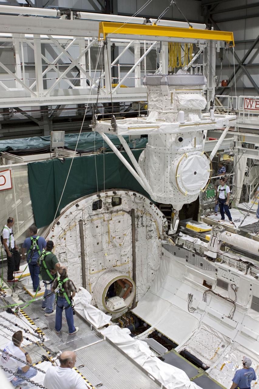 CAPE CANAVERAL, Fla. – At NASA's Kennedy Space Center in Florida, United Space Alliance technicians monitor operations as a crane is used to lift a mock air lock being prepared for installation in the payload bay of the space shuttle Atlantis in Bay 2 of the Orbiter Processing Facility. Atlantis is undergoing final preparations for its transfer to the Kennedy Space Center Visitor Complex targeted for November.      The work is part of Transition and Retirement of the remaining space shuttles, Atlantis and Endeavour. Atlantis is being prepared for public display at Kennedy's Visitor Complex. Over the course of its 26-year career, Atlantis spent 293 days in space during 33 missions. For more information, visit http://www.nasa.gov/transition Photo credit: NASA/Jim Grossmann
