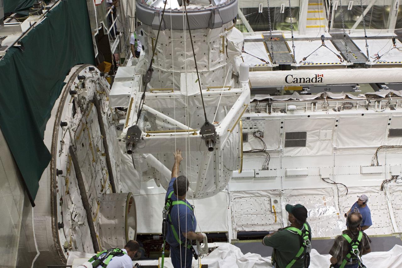 CAPE CANAVERAL, Fla. – At NASA's Kennedy Space Center in Florida, United Space Alliance technicians monitor operations as a crane is used to lift a mock air lock being prepared for installation in the payload bay of the space shuttle Atlantis in Bay 2 of the Orbiter Processing Facility. Atlantis is undergoing final preparations for its transfer to the Kennedy Space Center Visitor Complex targeted for November.      The work is part of Transition and Retirement of the remaining space shuttles, Atlantis and Endeavour. Atlantis is being prepared for public display at Kennedy's Visitor Complex. Over the course of its 26-year career, Atlantis spent 293 days in space during 33 missions. For more information, visit http://www.nasa.gov/transition Photo credit: NASA/Jim Grossmann