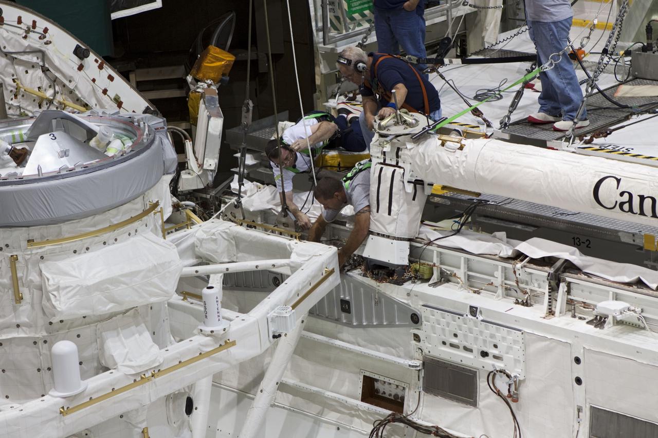 CAPE CANAVERAL, Fla. – At NASA's Kennedy Space Center in Florida, United Space Alliance technicians install a mock air lock in the payload bay of the space shuttle Atlantis in Bay 2 of the Orbiter Processing Facility. Atlantis is undergoing final preparations for its transfer to the Kennedy Space Center Visitor Complex targeted for November.      The work is part of Transition and Retirement of the remaining space shuttles, Atlantis and Endeavour. Atlantis is being prepared for public display at Kennedy's Visitor Complex. Over the course of its 26-year career, Atlantis spent 293 days in space during 33 missions. For more information, visit http://www.nasa.gov/transition Photo credit: NASA/Jim Grossmann