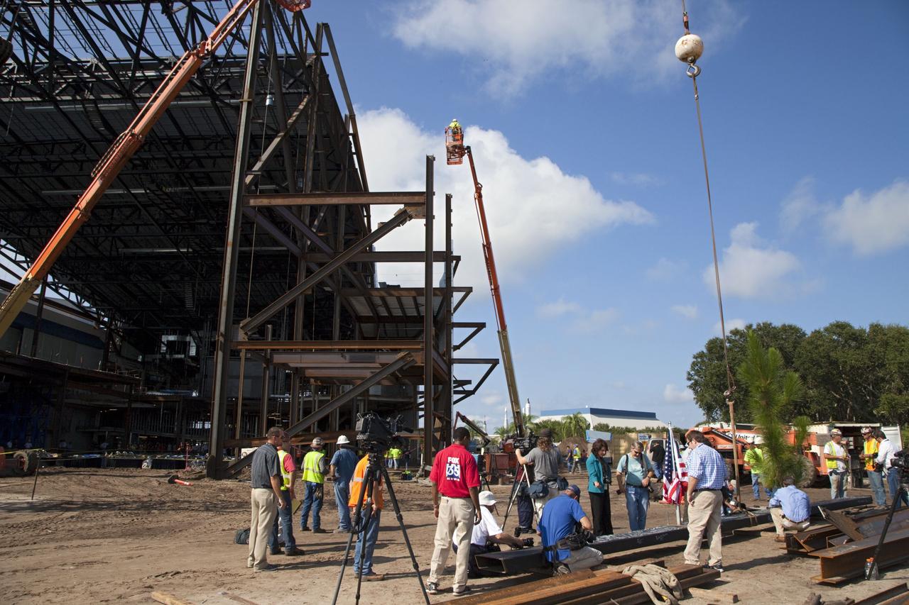 CAPE CANAVERAL, Fla. – Workers sign a steel beam before it is placed at the highest point of a new exhibit facility under construction at the Kennedy Space Center Visitor Complex. The 90,000-square-foot facility will house space shuttle Atlantis and 62 shuttle program exhibits. Photo credit: NASA/Kim Shiflett