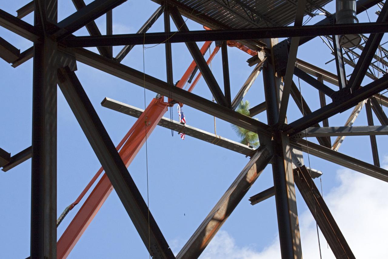 CAPE CANAVERAL, Fla. – A steel beam is lifted to the highest point of a new exhibit facility under construction at the Kennedy Space Center Visitor Complex. The 90,000-square-foot facility will house space shuttle Atlantis and 62 shuttle program exhibits. Photo credit: NASA/Kim Shiflett