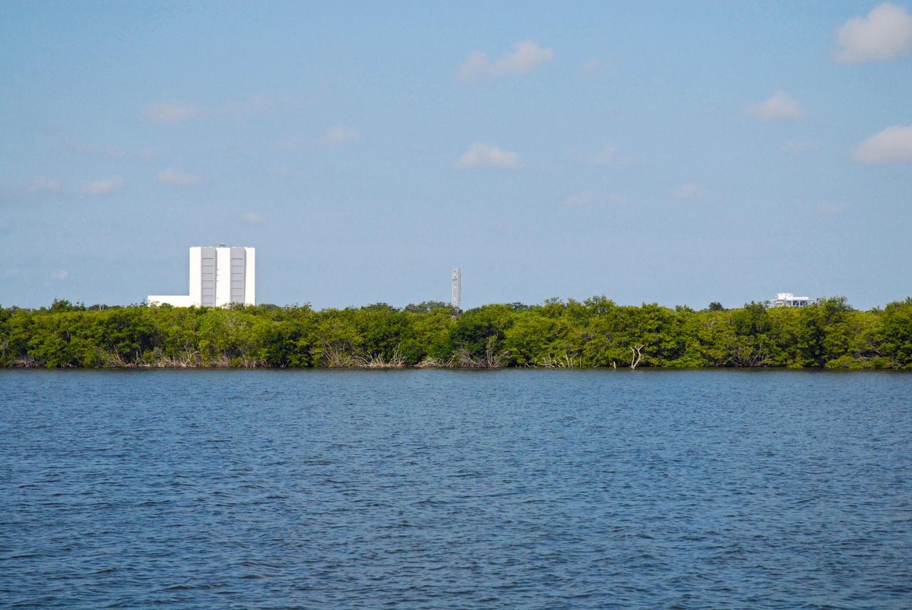 CAPE CANAVERAL, Fla. – The Vehicle Assembly Building, or VAB, and NASA's new mobile launcher, or ML, are seen in the distance during a field-guided boat tour of NASA's Kennedy Space Center in Florida. As part of the center's first-ever Innovation Expo, the tour, called "Living Outdoor Laboratory for Environmental Sustainability," is giving employees the opportunity to see the unique estuarine ecosystems that are protected from development by the presence of Kennedy and the Merritt Island National Wildlife Refuge. The 355-foot-tall ML structure, which took about two years to construct, will be modified by NASA’s Ground Systems Development and Operations, or GSDO, Program to support NASA’s Space Launch System, the heavy-lift rocket that will launch astronauts into deep space on future exploration missions.        The diverse and healthy area encompassing about 140,000 acres of central Florida's east coast has been closed to the public for 50 years, allowing the coastal dunes, saltwater estuaries and marshes, freshwater impoundments, scrub, pine flatwoods, and hardwood hammocks to provide habitats for more than 1,000 species of plants and animals. Innovation Expo is showcasing the innovative work taking place throughout the center's facilities and labs to encourage employees to work together to solve future challenges. For more information, visit http://www.nasa.gov/kennedy. Photo credit: NASA