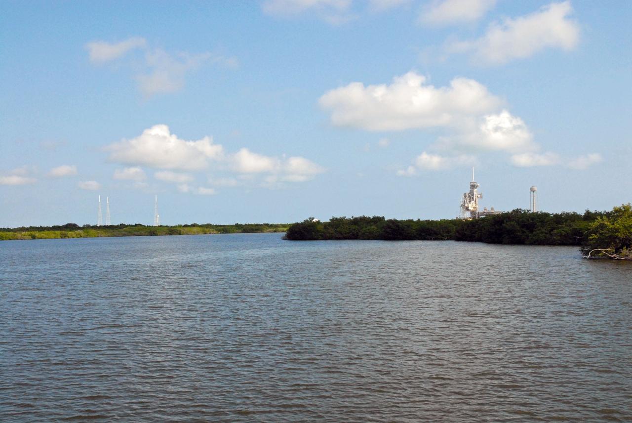 CAPE CANAVERAL, Fla. – Launch Pads 39A, right, and 39B, left, are seen in the distance during a field-guided boat tour of NASA's Kennedy Space Center in Florida. As part of the center's first-ever Innovation Expo, the tour, called "Living Outdoor Laboratory for Environmental Sustainability," is giving employees the opportunity to see the unique estuarine ecosystems that are protected from development by the presence of Kennedy and the Merritt Island National Wildlife Refuge. The diverse and healthy area encompassing about 140,000 acres of central Florida's east coast has been closed to the public for 50 years, allowing the coastal dunes, saltwater estuaries and marshes, freshwater impoundments, scrub, pine flatwoods, and hardwood hammocks to provide habitats for more than 1,000 species of plants and animals. Innovation Expo is showcasing the innovative work taking place throughout the center's facilities and labs to encourage employees to work together to solve future challenges. For more information, visit http://www.nasa.gov/kennedy. Photo credit: NASA