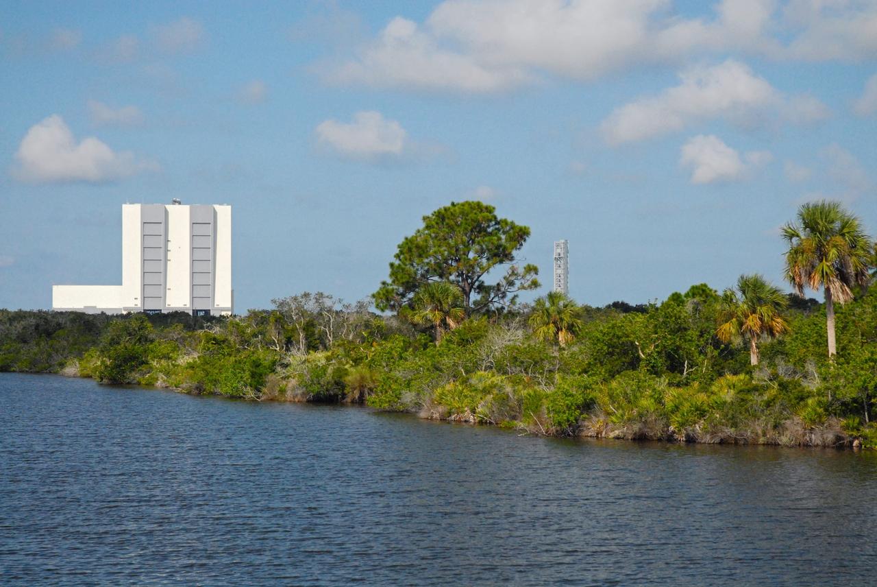 CAPE CANAVERAL, Fla. – The Vehicle Assembly Building, or VAB, and NASA's new mobile launcher, or ML, are seen in the distance during a field-guided boat tour of NASA's Kennedy Space Center in Florida. As part of the center's first-ever Innovation Expo, the tour, called "Living Outdoor Laboratory for Environmental Sustainability," is giving employees the opportunity to see the unique estuarine ecosystems that are protected from development by the presence of Kennedy and the Merritt Island National Wildlife Refuge. The 355-foot-tall ML structure, which took about two years to construct, will be modified by NASA’s Ground Systems Development and Operations, or GSDO, Program to support NASA’s Space Launch System, the heavy-lift rocket that will launch astronauts into deep space on future exploration missions.          The diverse and healthy area encompassing about 140,000 acres of central Florida's east coast has been closed to the public for 50 years, allowing the coastal dunes, saltwater estuaries and marshes, freshwater impoundments, scrub, pine flatwoods, and hardwood hammocks to provide habitats for more than 1,000 species of plants and animals. Innovation Expo is showcasing the innovative work taking place throughout the center's facilities and labs to encourage employees to work together to solve future challenges. For more information, visit http://www.nasa.gov/kennedy. Photo credit: NASA