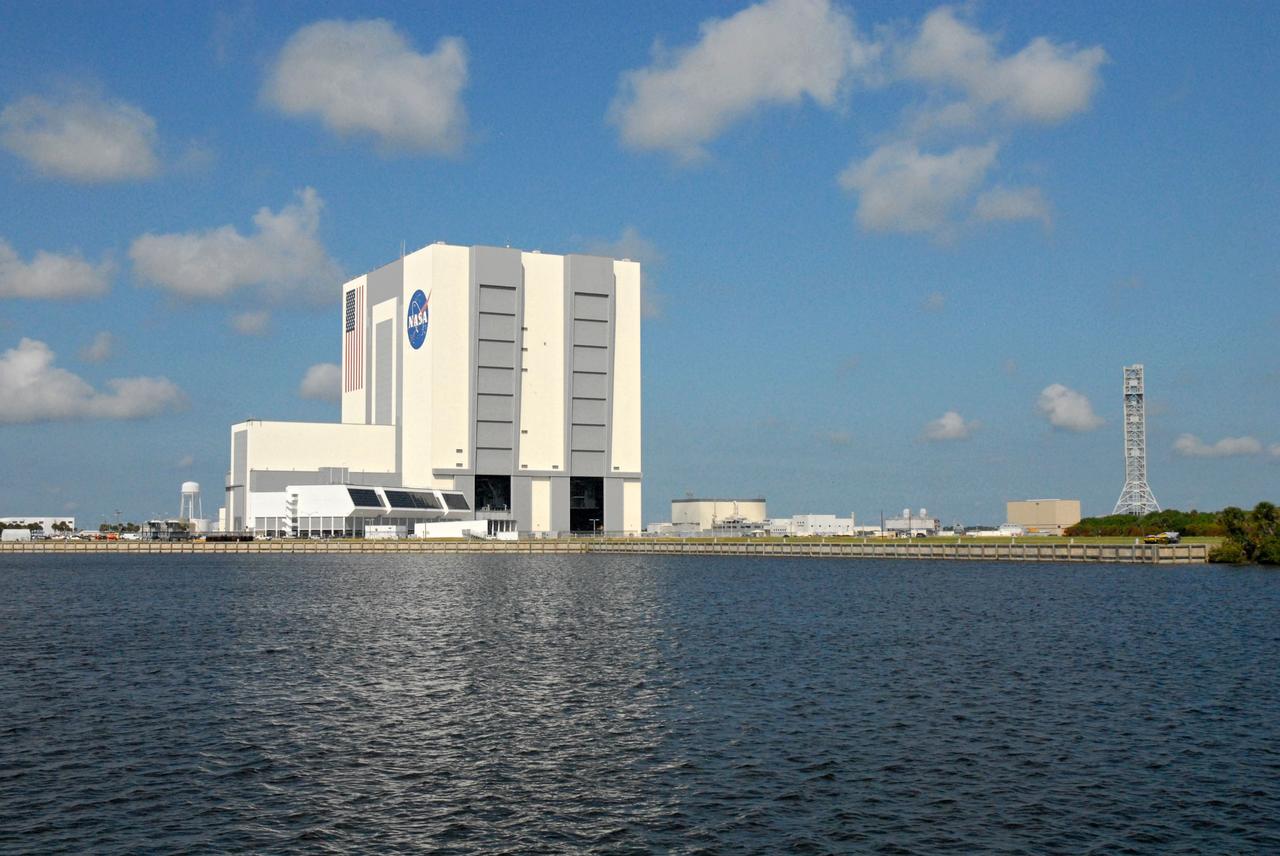 CAPE CANAVERAL, Fla. – The Vehicle Assembly Building, or VAB, and NASA's new mobile launcher, or ML, are seen during a field-guided boat tour of NASA's Kennedy Space Center in Florida. As part of the center's first-ever Innovation Expo, the tour, called "Living Outdoor Laboratory for Environmental Sustainability," is giving employees the opportunity to see the unique estuarine ecosystems that are protected from development by the presence of Kennedy and the Merritt Island National Wildlife Refuge. The 355-foot-tall ML structure, which took about two years to construct, will be modified by NASA’s Ground Systems Development and Operations, or GSDO, Program to support NASA’s Space Launch System, the heavy-lift rocket that will launch astronauts into deep space on future exploration missions.  The diverse and healthy area encompassing about 140,000 acres of central Florida's east coast has been closed to the public for 50 years, allowing the coastal dunes, saltwater estuaries and marshes, freshwater impoundments, scrub, pine flatwoods, and hardwood hammocks to provide habitats for more than 1,000 species of plants and animals. Innovation Expo is showcasing the innovative work taking place throughout the center's facilities and labs to encourage employees to work together to solve future challenges. For more information, visit http://www.nasa.gov/kennedy. Photo credit: NASA