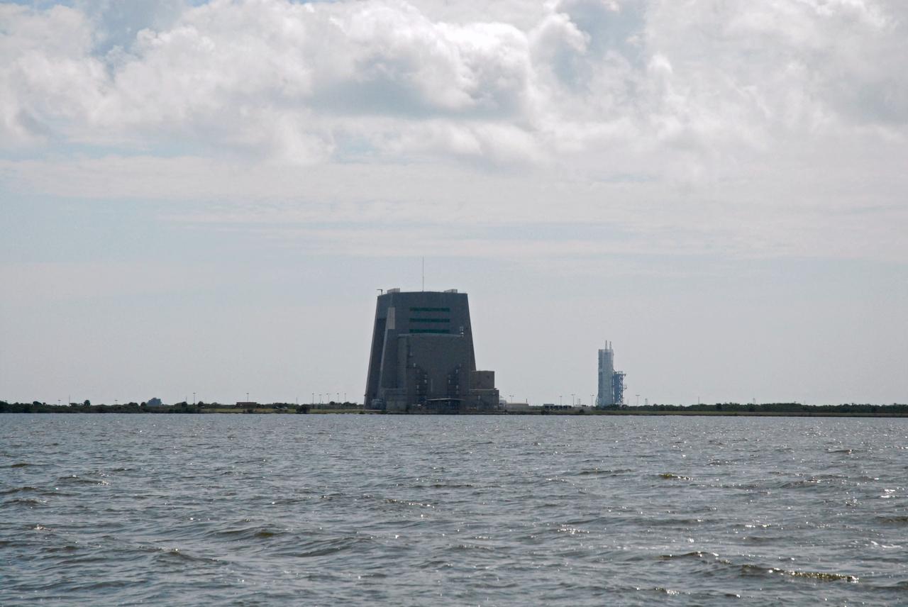 CAPE CANAVERAL, Fla. – Cape Canaveral Air Force Station's Solid Motor Assembly Building, or SMAB, and Launch Complex 37 are seen in the distance during a field-guided boat tour of NASA's Kennedy Space Center in Florida. As part of the center's first-ever Innovation Expo, the tour, called "Living Outdoor Laboratory for Environmental Sustainability," is giving employees the opportunity to see the unique estuarine ecosystems that are protected from development by the presence of Kennedy and the Merritt Island National Wildlife Refuge.         The diverse and healthy area encompassing about 140,000 acres of central Florida's east coast has been closed to the public for 50 years, allowing the coastal dunes, saltwater estuaries and marshes, freshwater impoundments, scrub, pine flatwoods, and hardwood hammocks to provide habitats for more than 1,000 species of plants and animals. Innovation Expo is showcasing the innovative work taking place throughout the center's facilities and labs to encourage employees to work together to solve future challenges. For more information, visit http://www.nasa.gov/kennedy. Photo credit: NASA