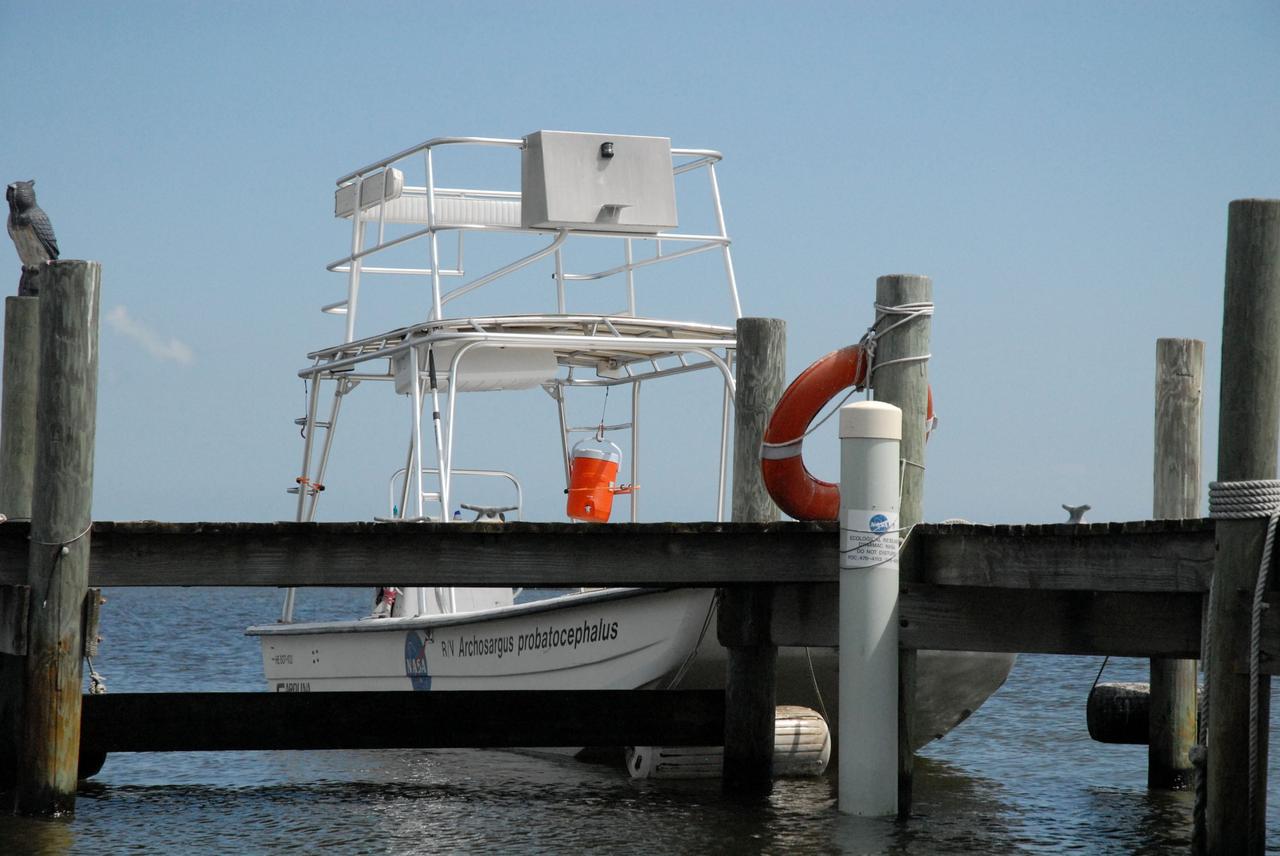 CAPE CANAVERAL, Fla. – A boat dock and skiff boat are seen near the Roy D. Bridges Jr. Bridge that connects NASA Kennedy Space Center's Industrial Area to Cape Canaveral Air Force Station's Industrial Area following a field-guided boat tour. As part of the Kennedy's first-ever Innovation Expo, the tour, called "Living Outdoor Laboratory for Environmental Sustainability," is giving employees the opportunity to see the unique estuarine ecosystems that are protected from development by the presence of the center and the Merritt Island National Wildlife Refuge.     The diverse and healthy area encompassing about 140,000 acres of central Florida's east coast has been closed to the public for 50 years, allowing the coastal dunes, saltwater estuaries and marshes, freshwater impoundments, scrub, pine flatwoods, and hardwood hammocks to provide habitats for more than 1,000 species of plants and animals. Innovation Expo is showcasing the innovative work taking place throughout the center's facilities and labs to encourage employees to work together to solve future challenges. For more information, visit http://www.nasa.gov/kennedy. Photo credit: NASA