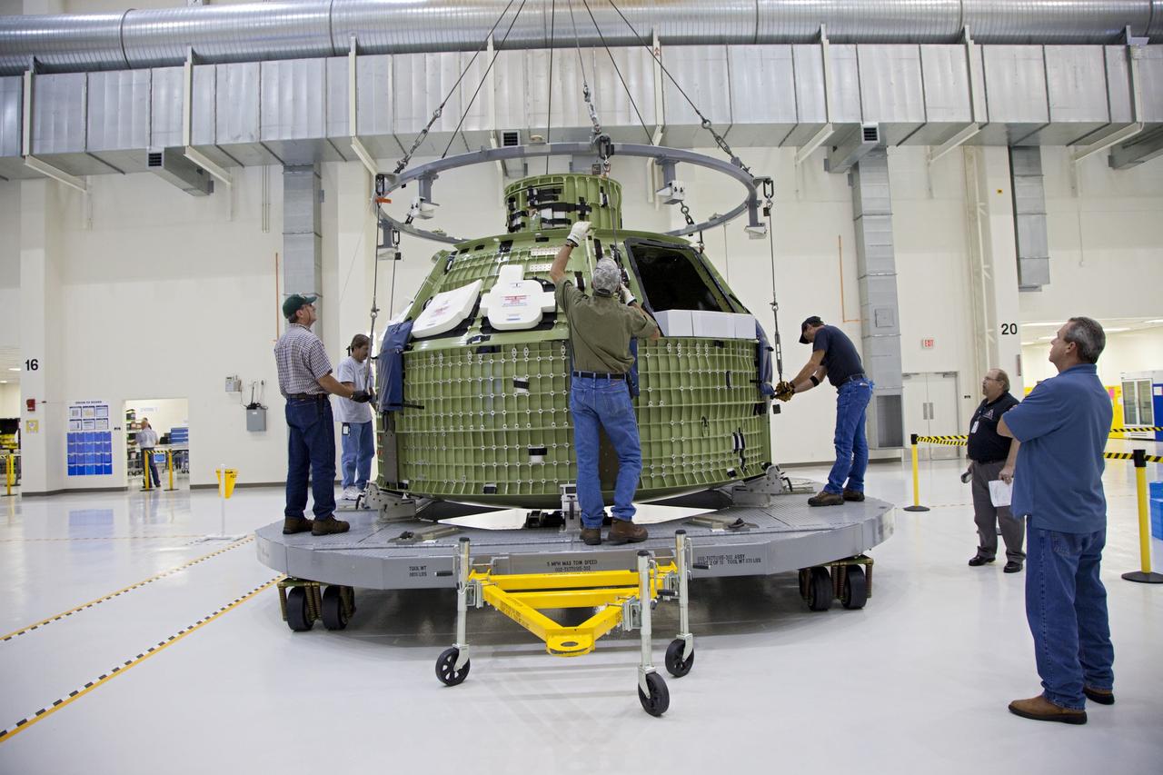 CAPE CANAVERAL, Fla. – Inside the Operations and Checkout Building high bay at NASA’s Kennedy Space Center in Florida, technicians attach a crane to the Orion Exploration Flight Test 1 crew module so that it can be moved to the base of a birdcage tool. The birdcage will be used to continue installation of external components in preparation for Orion’s first uncrewed test flight in 2014 atop a Delta IV rocket. Orion is the exploration spacecraft designed to carry crews to space beyond low Earth orbit. It will provide emergency abort capability, sustain the crew during the space travel and provide safe re-entry from deep space return velocities. A second uncrewed flight test is scheduled for 2017 on NASA’s Space Launch System rocket. For more information, visit http://www.nasa.gov/orion. Photo credit: NASA/Kim Shiflett