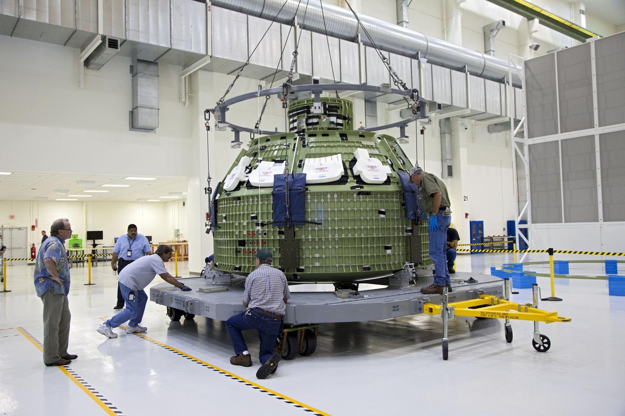 CAPE CANAVERAL, Fla. – Inside the Operations and Checkout Building high bay at NASA’s Kennedy Space Center in Florida, technicians attach a crane to the Orion Exploration Flight Test 1 crew module so that it can be moved to the base of a birdcage tool. The birdcage will be used to continue installation of external components in preparation for Orion’s first uncrewed test flight in 2014 atop a Delta IV rocket. Orion is the exploration spacecraft designed to carry crews to space beyond low Earth orbit. It will provide emergency abort capability, sustain the crew during the space travel and provide safe re-entry from deep space return velocities. A second uncrewed flight test is scheduled for 2017 on NASA’s Space Launch System rocket. For more information, visit http://www.nasa.gov/orion. Photo credit: NASA/Kim Shiflett