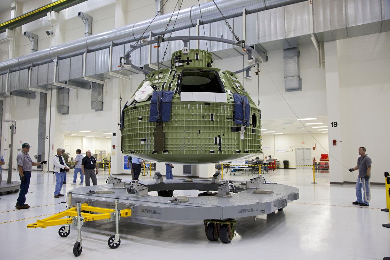 CAPE CANAVERAL, Fla. –Inside the Operations and Checkout Building at NASA’s Kennedy Space Center in Florida, technicians monitor the progress as a crane begins to lift the Orion Exploration Flight Test 1 crew module so that it can be moved to the base of a birdcage tool. The birdcage will be used to continue installation of external components in preparation for Orion’s first uncrewed test flight in 2014 atop a Delta IV rocket. Orion is the exploration spacecraft designed to carry crews to space beyond low Earth orbit. It will provide emergency abort capability, sustain the crew during the space travel and provide safe re-entry from deep space return velocities. A second uncrewed flight test is scheduled for 2017 on NASA’s Space Launch System rocket. For more information, visit http://www.nasa.gov/orion. Photo credit: NASA/Kim Shiflett