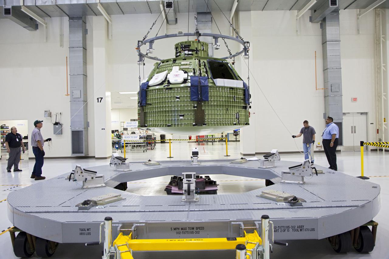 CAPE CANAVERAL, Fla. – Inside the Operations and Checkout Building at NASA’s Kennedy Space Center in Florida, technicians monitor the progress as a crane is used to move the Orion Exploration Flight Test 1 crew module to the base of a birdcage tool. The birdcage will be used to continue installation of external components in preparation for Orion’s first uncrewed test flight in 2014 atop a Delta IV rocket. Orion is the exploration spacecraft designed to carry crews to space beyond low Earth orbit. It will provide emergency abort capability, sustain the crew during the space travel and provide safe re-entry from deep space return velocities. A second uncrewed flight test is scheduled for 2017 on NASA’s Space Launch System rocket. For more information, visit http://www.nasa.gov/orion. Photo credit: NASA/Kim Shiflett