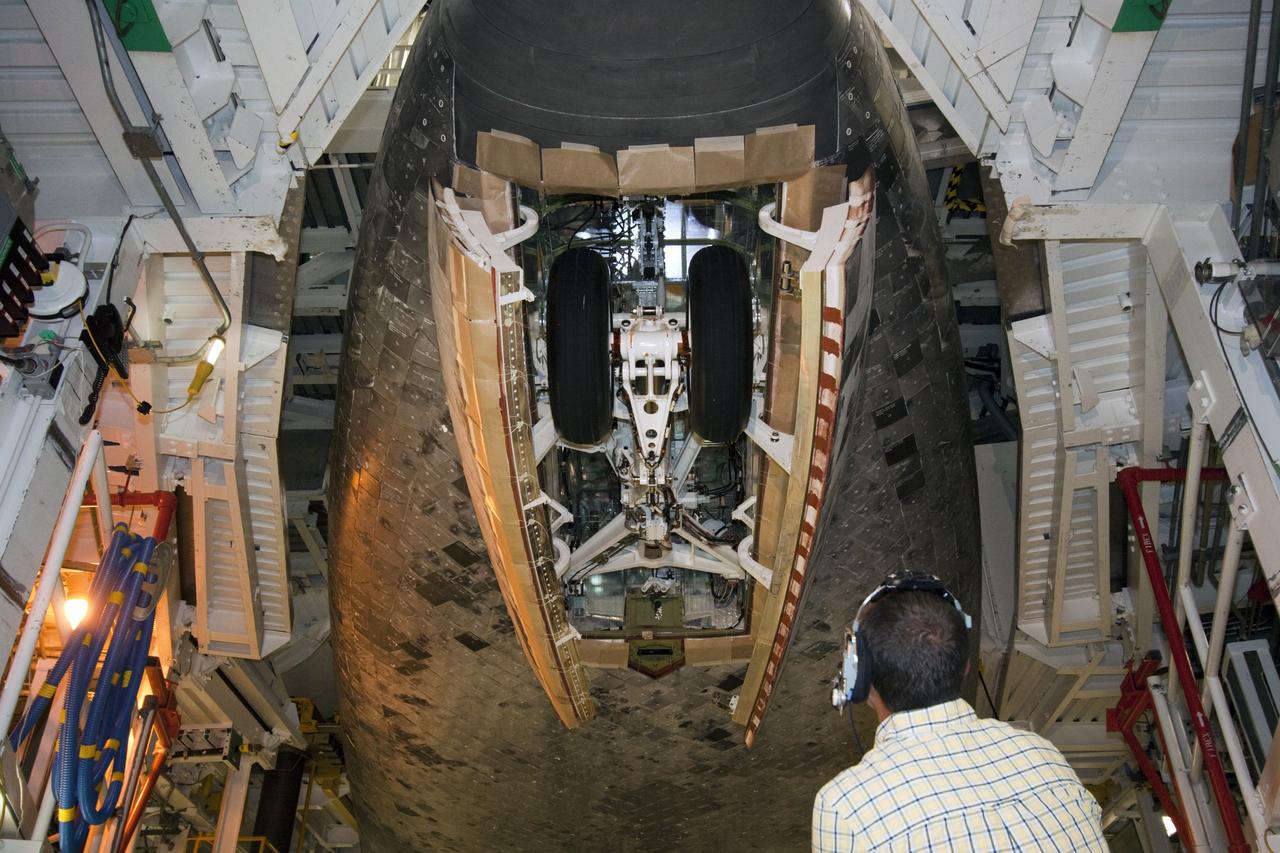 CAPE CANAVERAL, Fla. – A technician watches the nose gear on space shuttle Atlantis as it is stowed during a landing gear functional test in Orbiter Processing Facility-2, where the shuttle is undergoing transition and retirement processing. Photo credit: NASA/Jim Grossmann