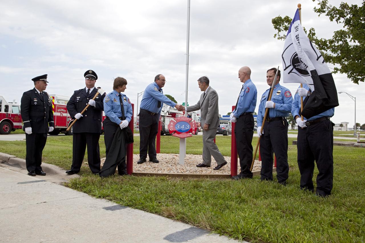 CAPE CANAVERAL, Fla. – At Fire Station 1 at NASA’s Kennedy Space Center in Florida, Fire and Rescue personnel stand at attention as Kennedy Director Robert Cabana participates in a 9/11 memorial dedication at Fire Station 1.    Kennedy Fire and Rescue Services commemorated the 11th anniversary of 9/11 with a ceremony that included a minute of silence at 10:28 a.m., which was the moment of collapse of the north tower of the World Trade Center. Kennedy center-wide emergency units dispatched by Fire Control engaged in one-minute sirens, the new memorial was dedicated and the Honor Guard performed a flag-folding ceremony. Photo credit: NASA/Dimitri Gerondidakis