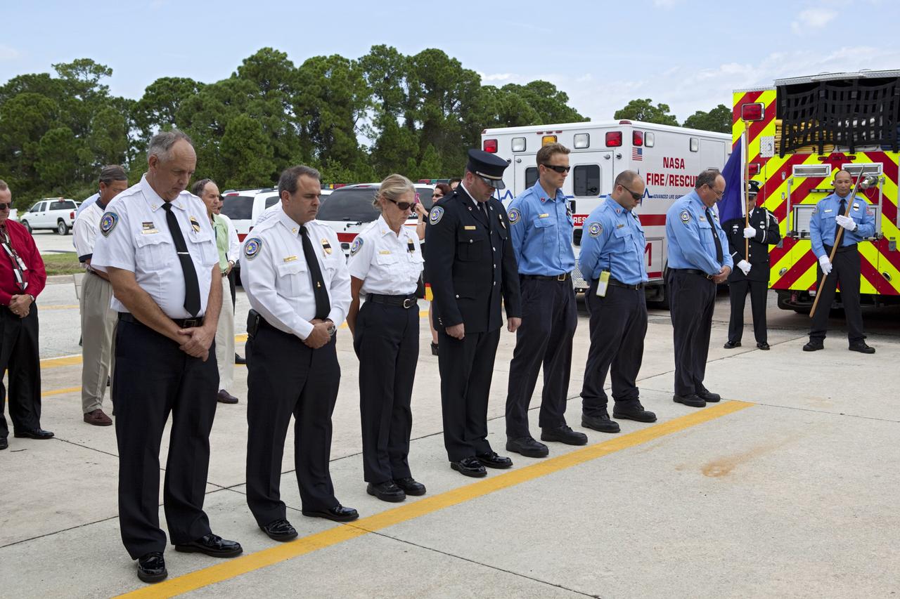 CAPE CANAVERAL, Fla. – At Fire Station 1 at NASA’s Kennedy Space Center in Florida, Fire and Rescue personnel pause for a moment of silence during the 9/11 memorial dedication ceremony.    Kennedy Fire and Rescue Services commemorated the 11th anniversary of 9/11 with a ceremony that included a minute of silence at 10:28 a.m., which was the moment of collapse of the north tower of the World Trade Center. Kennedy center-wide emergency units dispatched by Fire Control engaged in one-minute sirens, the new memorial was dedicated and the Honor Guard performed a flag-folding ceremony. Photo credit: NASA/Dimitri Gerondidakis