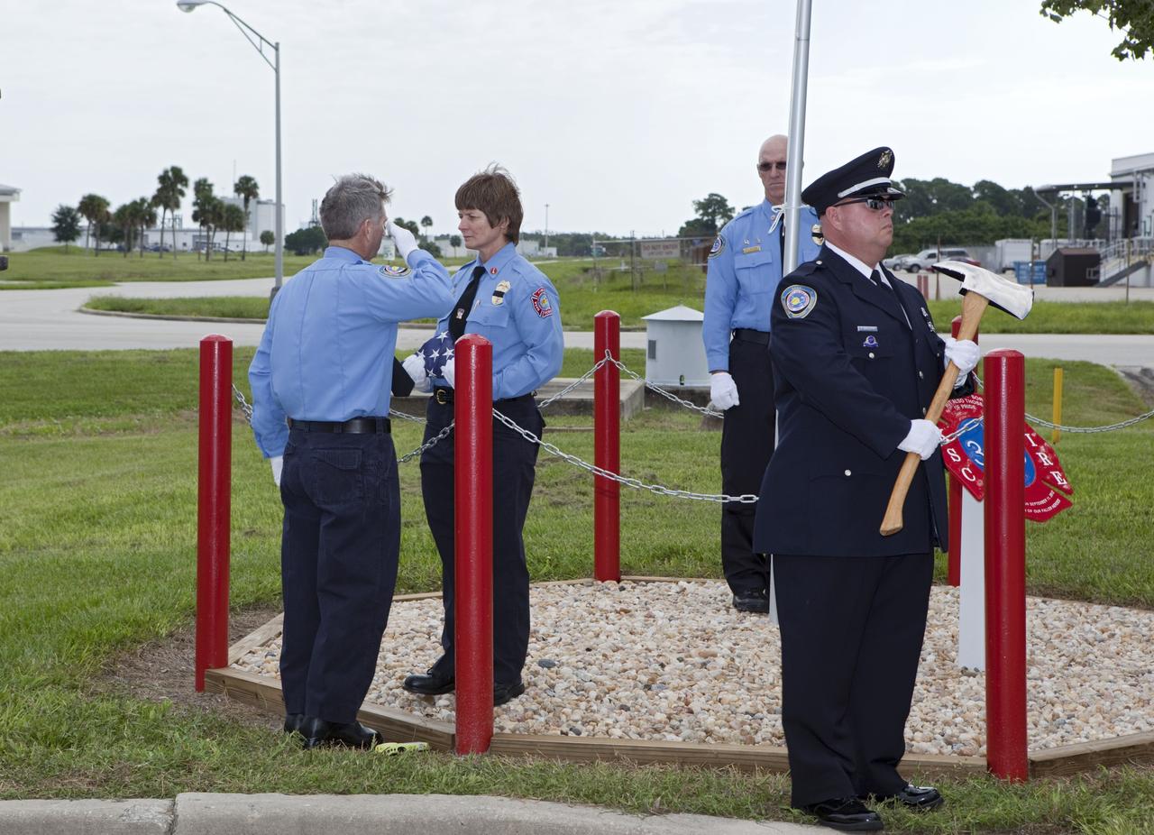 CAPE CANAVERAL, Fla. – At Fire Station 1 at NASA’s Kennedy Space Center in Florida, Fire and Rescue personnel salute or stand at attention during the 9/11 memorial dedication ceremony.    Kennedy Fire and Rescue Services commemorated the 11th anniversary of 9/11 with a ceremony that included a minute of silence at 10:28 a.m., which was the moment of collapse of the north tower of the World Trade Center. Kennedy center-wide emergency units dispatched by Fire Control engaged in one-minute sirens, the new memorial was dedicated and the Honor Guard performed a flag-folding ceremony. Photo credit: NASA/Dimitri Gerondidakis