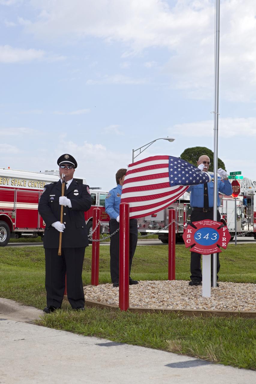 CAPE CANAVERAL, Fla. – At Fire Station 1 at NASA’s Kennedy Space Center in Florida, Fire and Rescue personnel salute as the American flag is raised during the 9/11 memorial dedication ceremony.    Kennedy Fire and Rescue Services commemorated the 11th anniversary of 9/11 with a ceremony that included a minute of silence at 10:28 a.m., which was the moment of collapse of the north tower of the World Trade Center. Kennedy center-wide emergency units dispatched by Fire Control engaged in one-minute sirens, the new memorial was dedicated and the Honor Guard performed a flag-folding ceremony. Photo credit: NASA/Dimitri Gerondidakis
