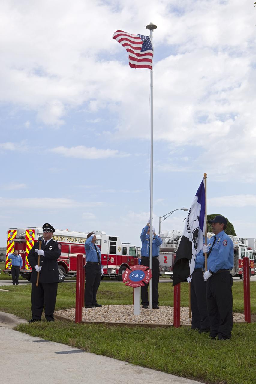 CAPE CANAVERAL, Fla. – At Fire Station 1 at NASA’s Kennedy Space Center in Florida, Fire and Rescue personnel salute as the American flag is raised during the 9/11 memorial dedication ceremony.    Kennedy Fire and Rescue Services commemorated the 11th anniversary of 9/11 with a ceremony that included a minute of silence at 10:28 a.m., which was the moment of collapse of the north tower of the World Trade Center. Kennedy center-wide emergency units dispatched by Fire Control engaged in one-minute sirens, the new memorial was dedicated and the Honor Guard performed a flag-folding ceremony. Photo credit: NASA/Dimitri Gerondidakis