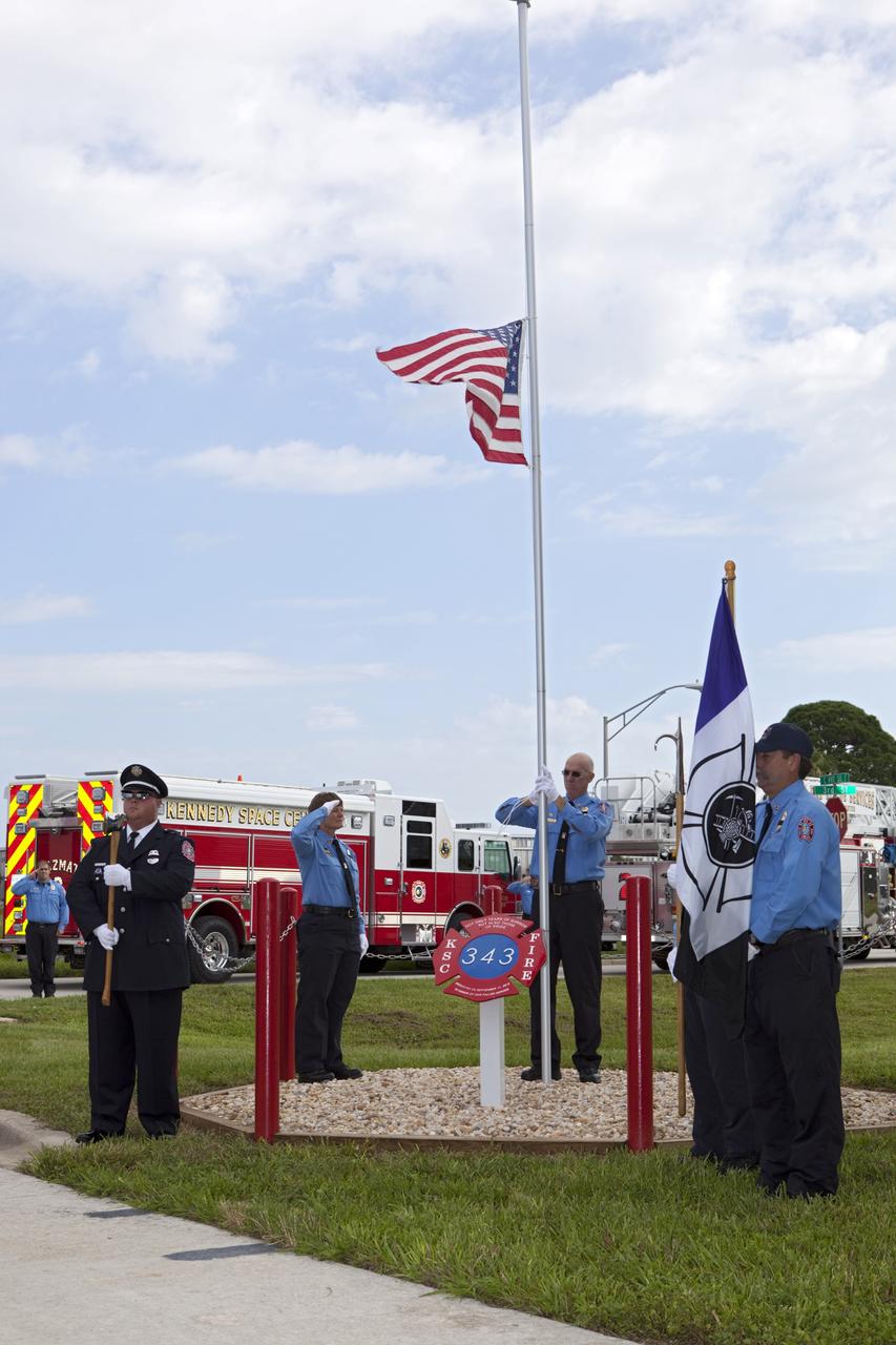 CAPE CANAVERAL, Fla. – At Fire Station 1 at NASA’s Kennedy Space Center in Florida, Fire and Rescue personnel salute as the American flag is raised during the 9/11 memorial dedication ceremony.    Kennedy Fire and Rescue Services commemorated the 11th anniversary of 9/11 with a ceremony that included a minute of silence at 10:28 a.m., which was the moment of collapse of the north tower of the World Trade Center. Kennedy center-wide emergency units dispatched by Fire Control engaged in one-minute sirens, the new memorial was dedicated and the Honor Guard performed a flag-folding ceremony. Photo credit: NASA/Dimitri Gerondidakis