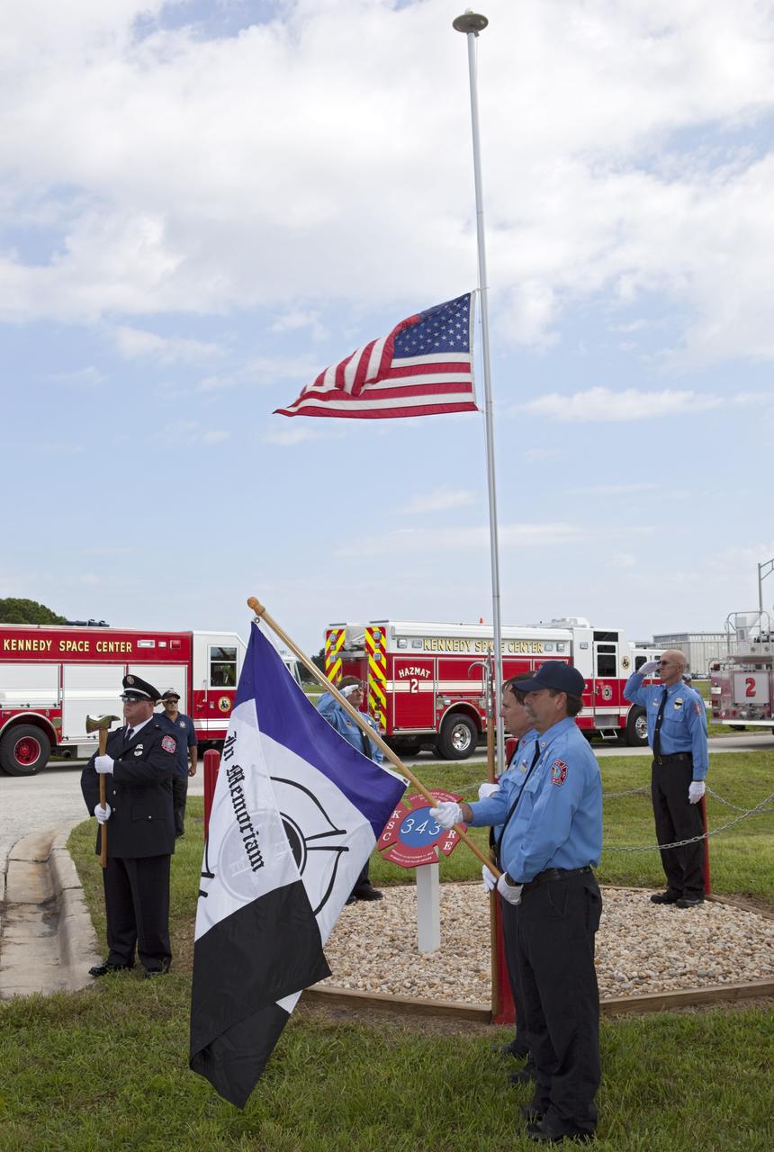 CAPE CANAVERAL, Fla. – At Fire Station 1 at NASA’s Kennedy Space Center in Florida, Fire and Rescue personnel salute or stand at attention as the American flag is raised during the 9/11 memorial dedication ceremony.    Kennedy Fire and Rescue Services commemorated the 11th anniversary of 9/11 with a ceremony that included a minute of silence at 10:28 a.m., which was the moment of collapse of the north tower of the World Trade Center. Kennedy center-wide emergency units dispatched by Fire Control engaged in one-minute sirens, the new memorial was dedicated and the Honor Guard performed a flag-folding ceremony. Photo credit: NASA/Dimitri Gerondidakis