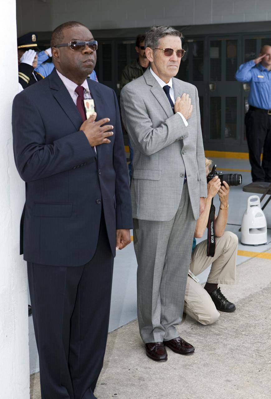 CAPE CANAVERAL, Fla. – At NASA’s Kennedy Space Center in Florida, from left, Thomas Keller, program manager with Chenega Security and Support Solutions on the Kennedy Protective Services contract, and Kennedy Space Center Director Robert Cabana stand at attention during the 9/11 memorial dedication ceremony at Fire Station 1.    Kennedy Fire and Rescue Services commemorated the 11th anniversary of 9/11 with a ceremony that included a minute of silence at 10:28 a.m., which was the moment of collapse of the north tower of the World Trade Center. Kennedy center-wide emergency units dispatched by Fire Control engaged in one-minute sirens, the new memorial was dedicated and the Honor Guard performed a flag-folding ceremony. Photo credit: NASA/Dimitri Gerondidakis