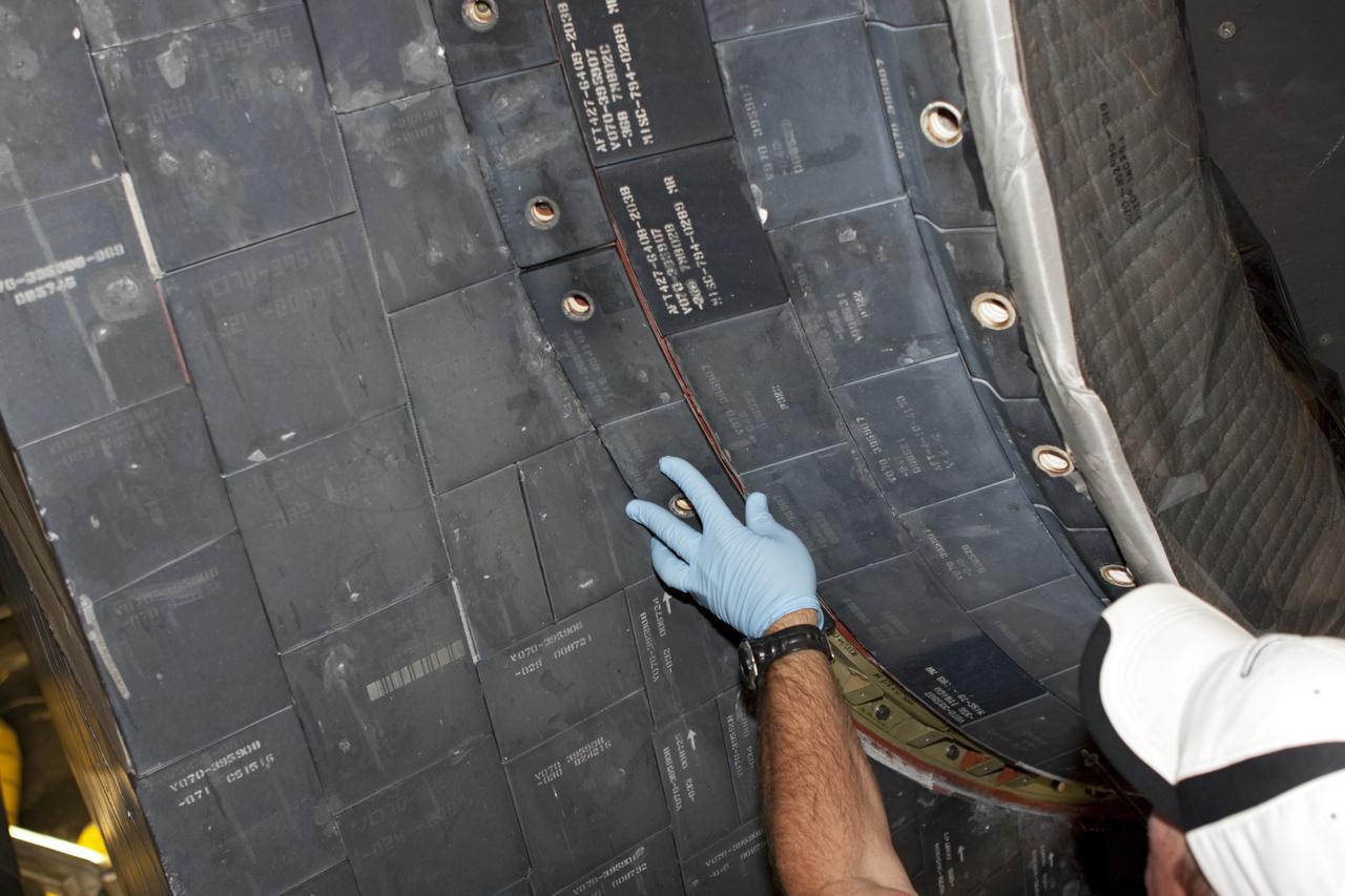 CAPE CANAVERAL, Fla. – At NASA's Kennedy Space Center in Florida, a United Space Alliance technician installs a main engine carrier panel on the space shuttle Atlantis in Bay 2 of the Orbiter Processing Facility. Atlantis is undergoing final preparations for its transfer to the Kennedy Space Center Visitor Complex targeted for November. The work is part of Transition and Retirement of the remaining space shuttles, Atlantis and Endeavour. Atlantis is being prepared for public display at Kennedy's Visitor Complex. Over the course of its 26-year career, Atlantis spent 293 days in space during 33 missions. For more information, visit http://www.nasa.gov/transition Photo credit: NASA/Jim Grossmann