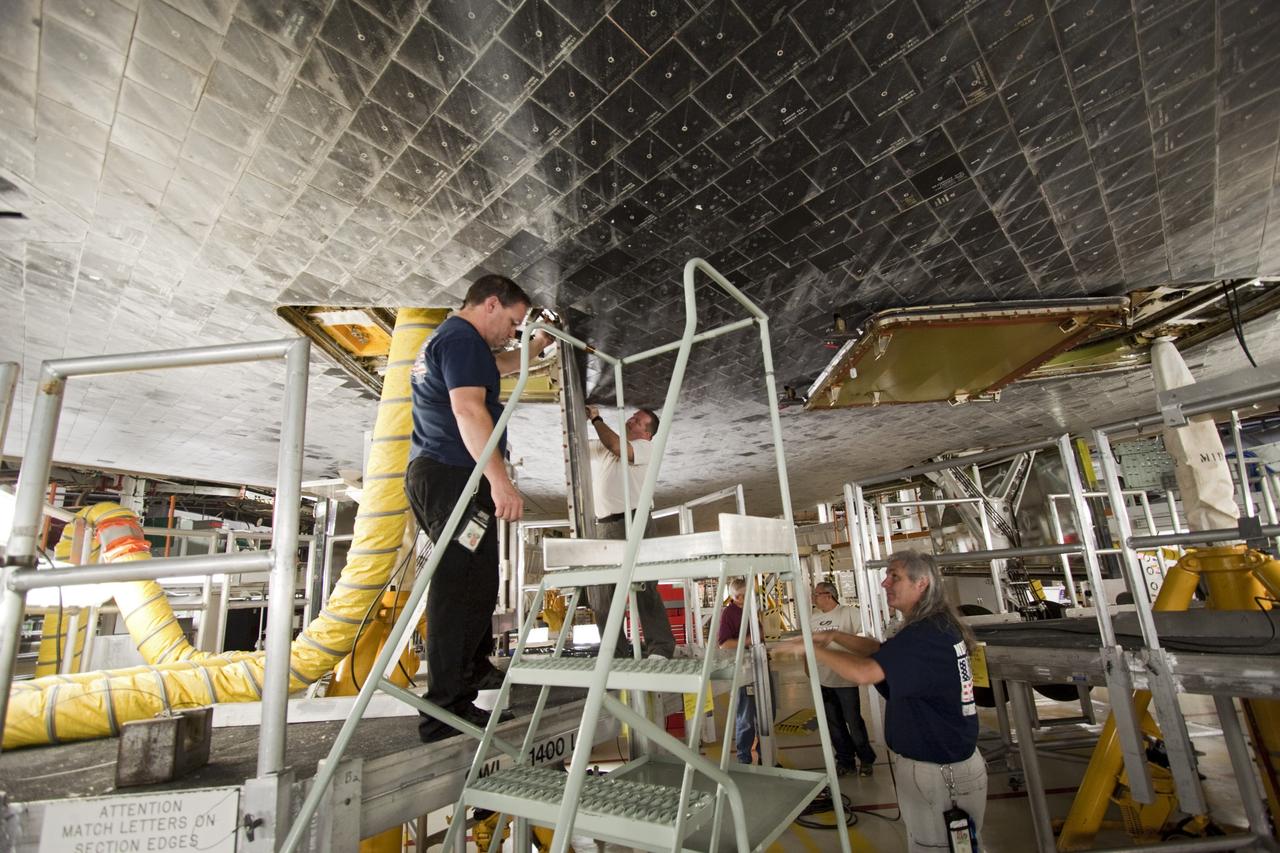 CAPE CANAVERAL, Fla. – In Bay 2 of the Orbiter Processing Facility at NASA's Kennedy Space Center in Florida, United Space Alliance technicians remove the two external fuel tank doors from the space shuttle Atlantis. Atlantis is undergoing final preparations for its transfer to the Kennedy Space Center Visitor Complex targeted for November. The work is part of Transition and Retirement of the remaining space shuttles, Atlantis and Endeavour. Atlantis is being prepared for public display at Kennedy's Visitor Complex. Over the course of its 26-year career, Atlantis spent 293 days in space during 33 missions. For more information, visit http://www.nasa.gov/transition Photo credit: NASA/Jim Grossmann